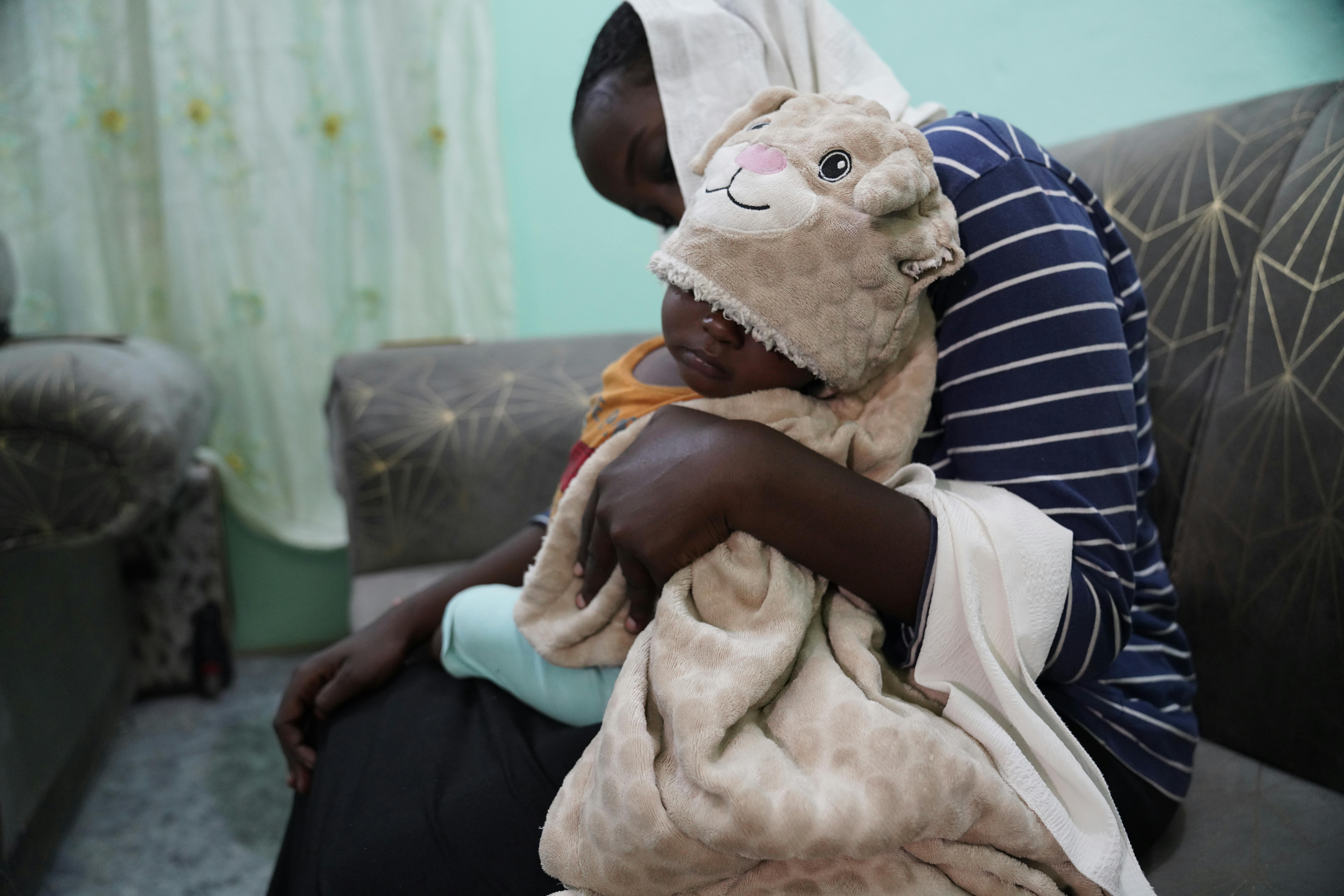 Aman*, 8 mesi, è seduto sulle ginocchia della madre, Hala*, tra le ragazze colpite dalla violenza sessuale scoppiata in Sudan durante il conflitto. Hala ora ha chiesto supporto all'organizzazione guidata da donne contro la violenza di genere