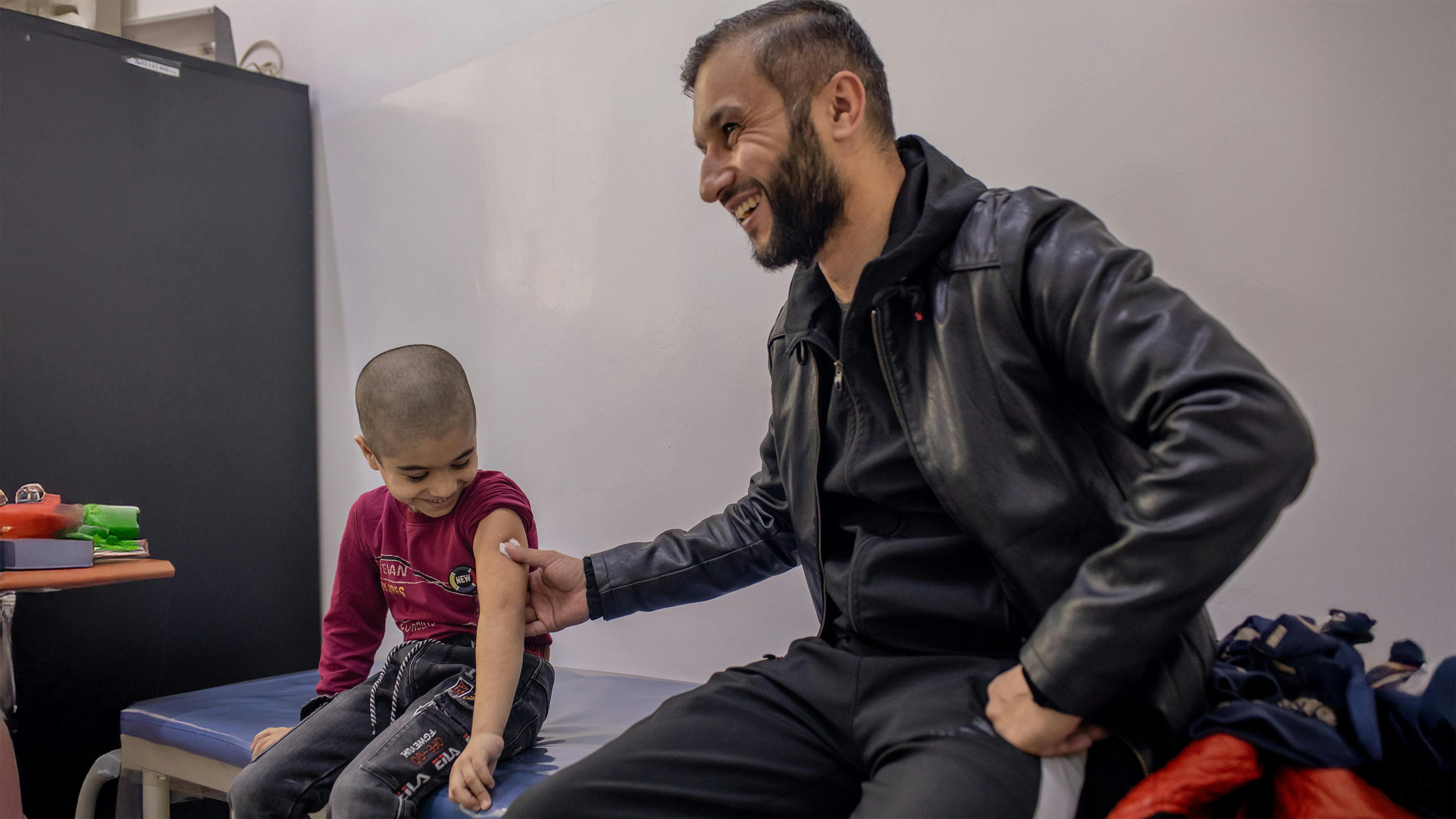 Dushanbe - Tagikistan, Muso Ahliddinzoda, 6 anni, sorride con suo padre dopo essere stato vaccinato  presso il Centro sanitario di Dushanbe numero 9.