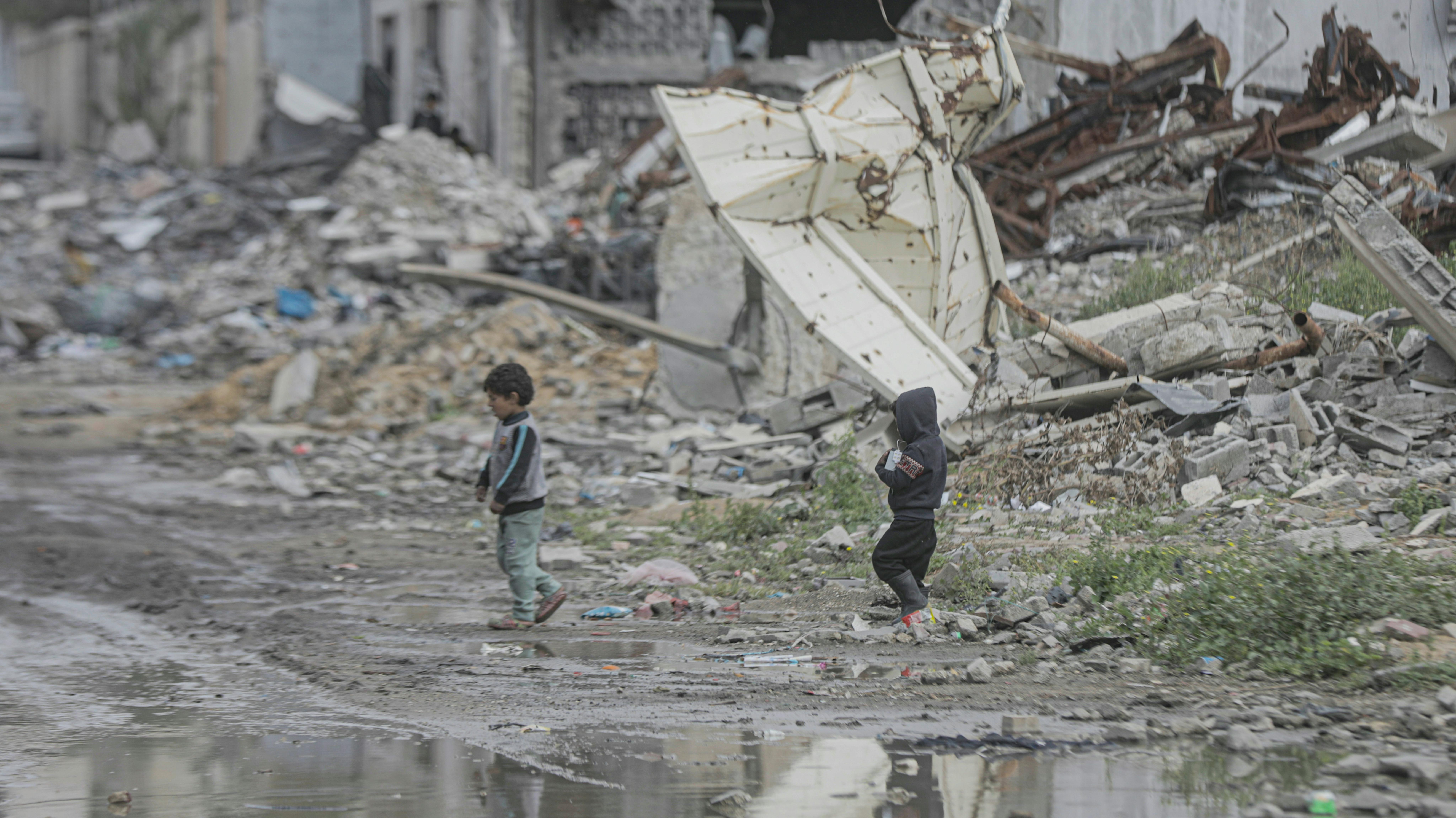 Gaza City - Due bambini guadano nel mezzo di una grande piscina formata da infrastrutture distrutte.