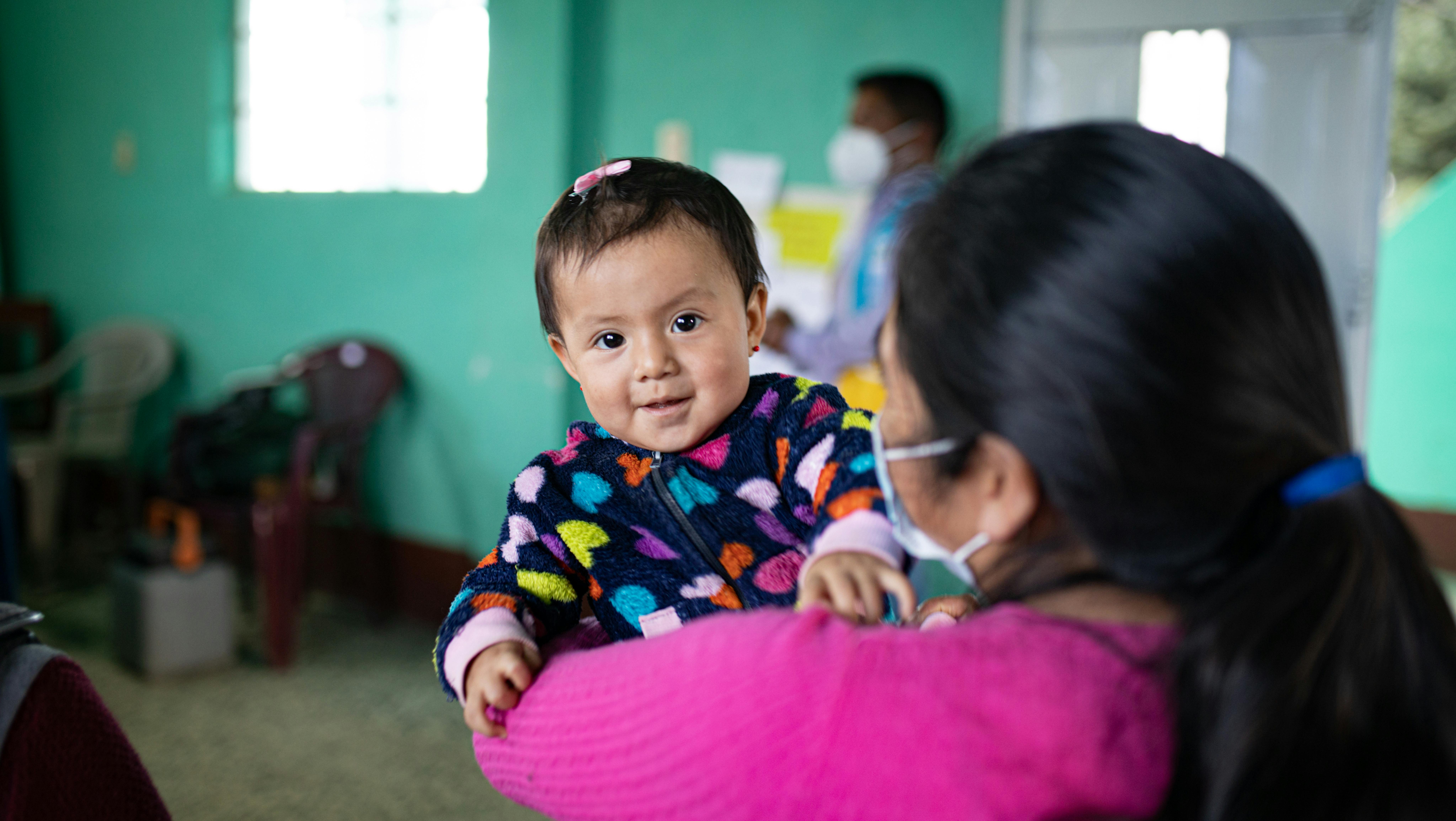 Guatemala, Lidia Chun (40 anni) partecipa con sua figlia Maria Chun (1 anno) a un workshop sulla protezione dei bambini nella sala della comunità di Tejutla, San Marcos