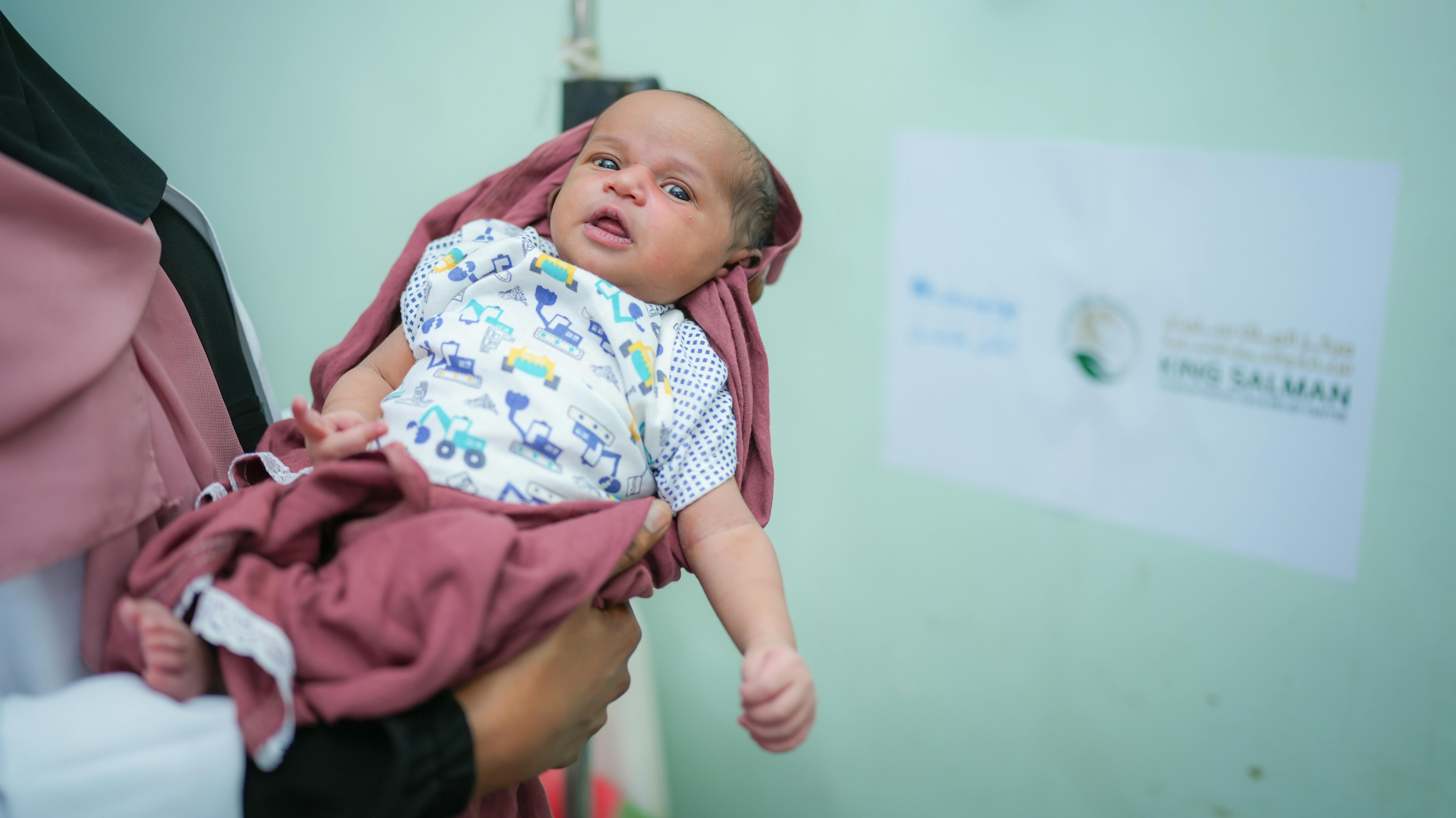 Yemen - L'ostetrica, Dhekra, 27 anni, tiene in braccio il neonato, Saleh, nato 3 giorni fa all'ospedale Mahnaf