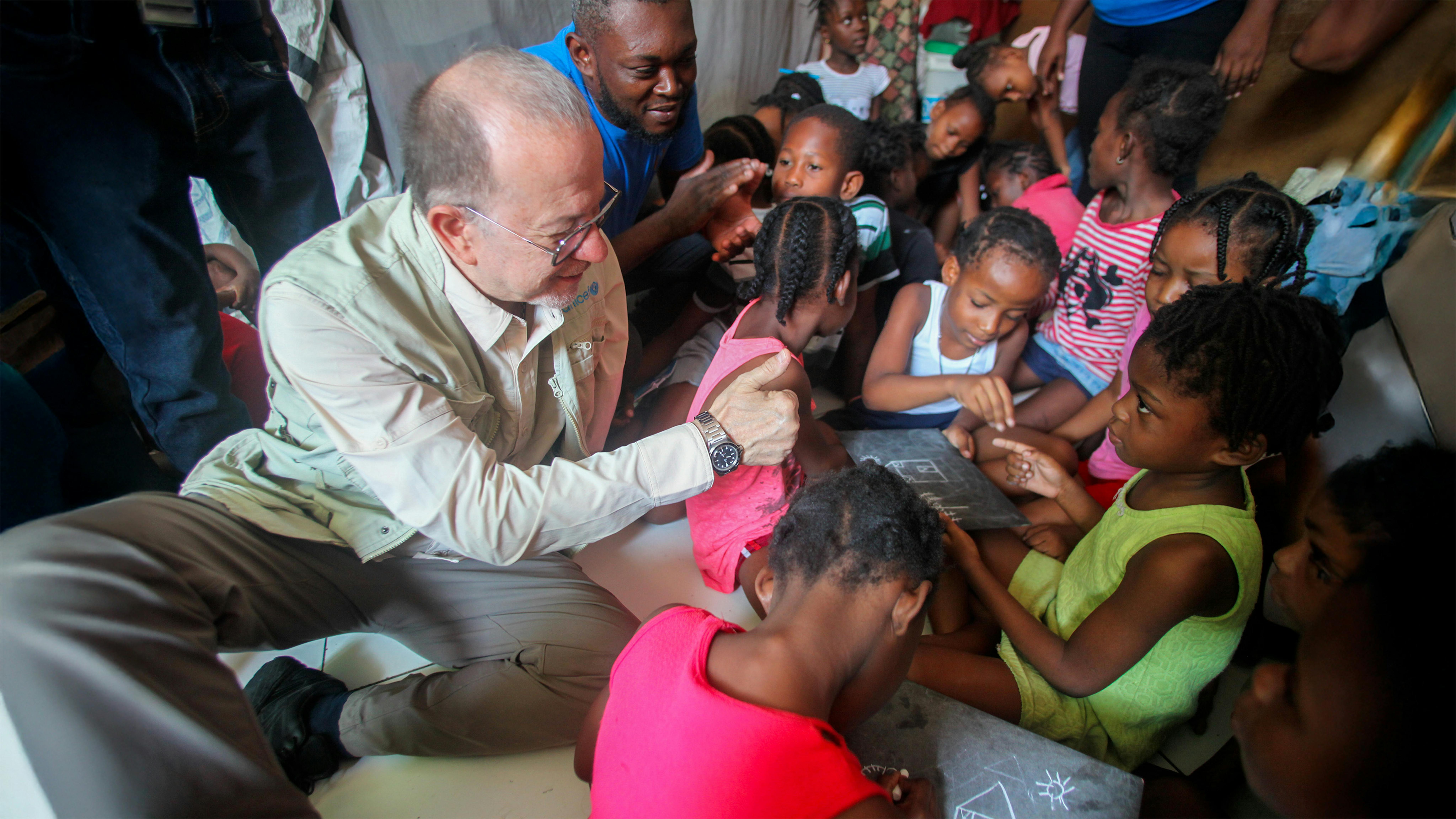 Il Vice Direttore Generale dell'UNICEF Ted Chaiban gioca con i bambini nel sito per sfollati interni del Lycée Marie Jeanne, Port-au-Prince, Haiti.