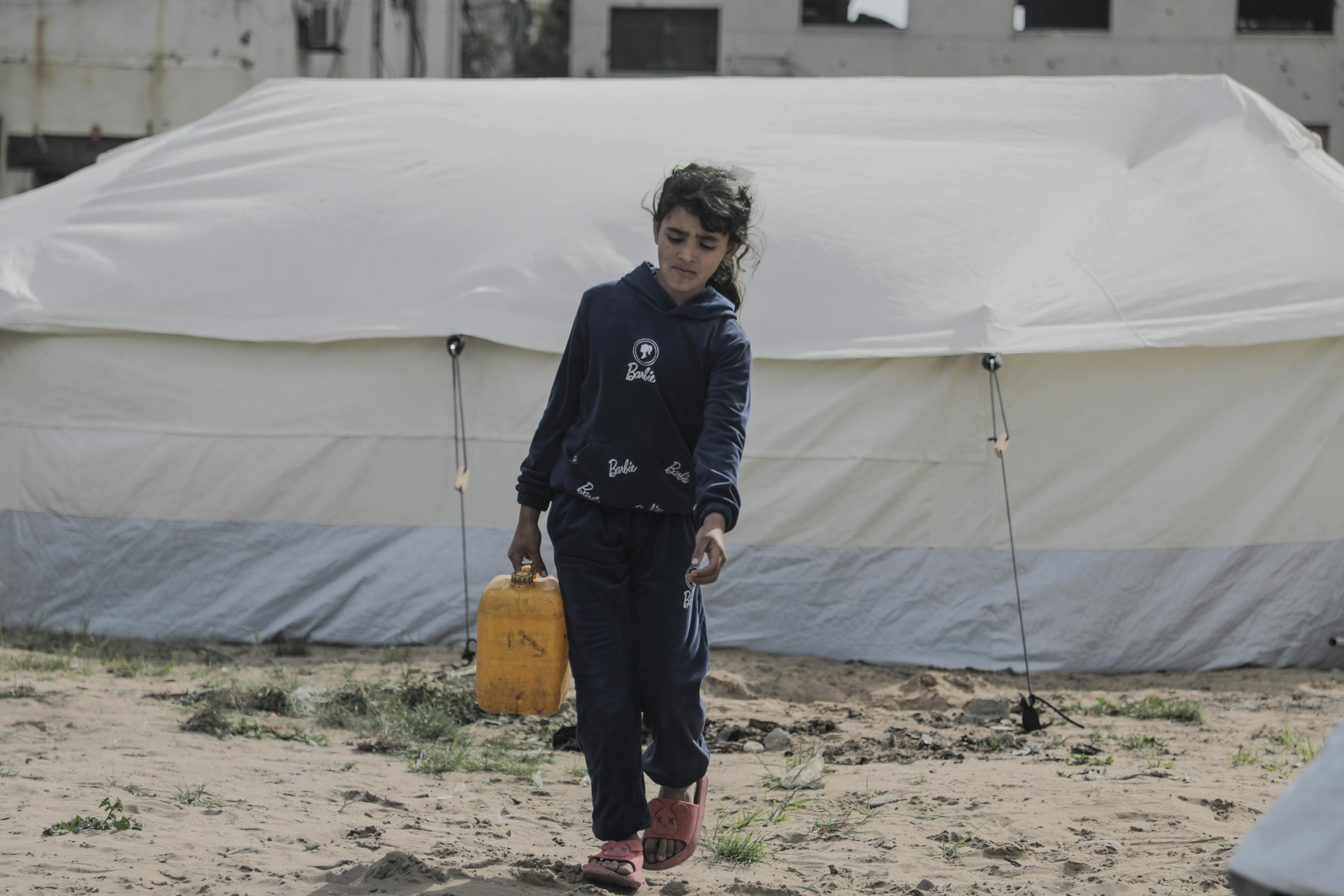 Lina aiuta a raccogliere l'acqua per la sua famiglia.  "La guerra è iniziata quando avevo nove anni." racconta "Ora ne ho 11. Non so nemmeno come sono cresciuta. Fermate la guerra".