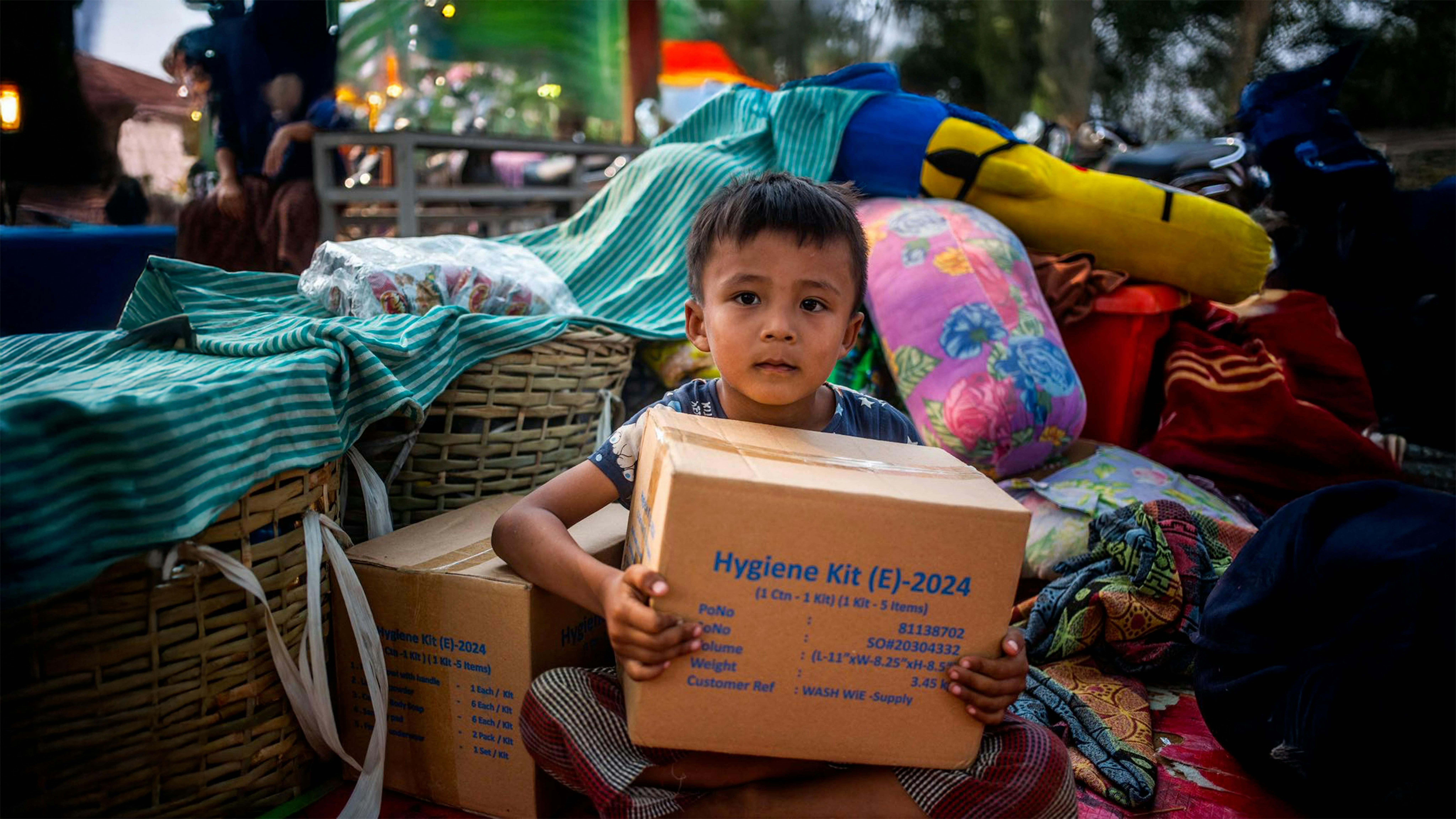 Phone Payae, 5 anni, posa per una foto con in mano una scatola di forniture WASH dell'UNICEF nella regione di Sagaing, dopo il terremoto di magnitudo 7,7 che ha colpito il Myanmar