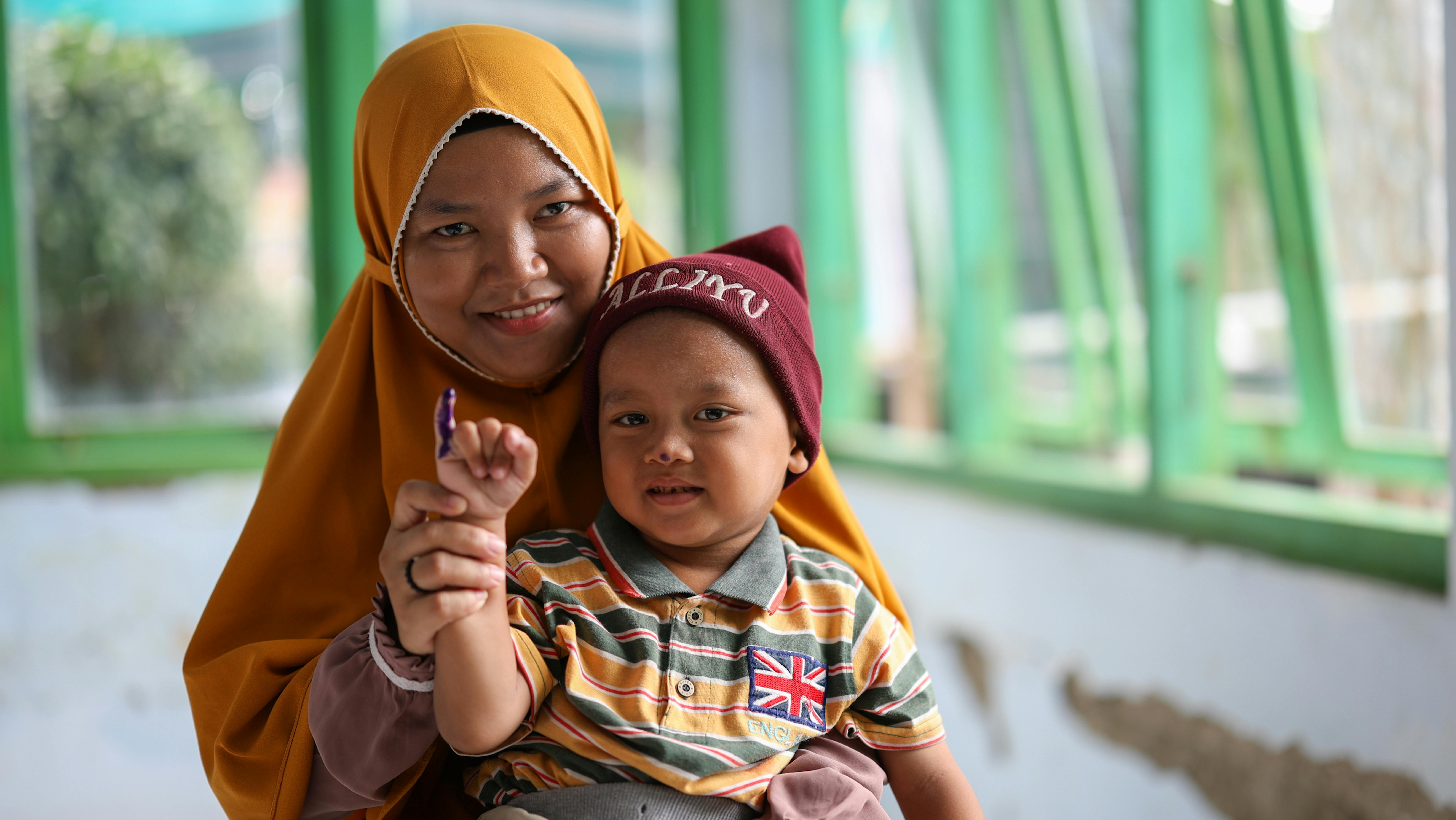 Alliyu (3 anni) accompagnato da sua madre Ratiyani (29 anni), scatta una foto dopo essere stato immunizzato contro la poliomielite durante il 2° turno della Sottosettimana Nazionale di Immunizzazione contro la Polio presso la sede centrale del villaggio di Banjardawa