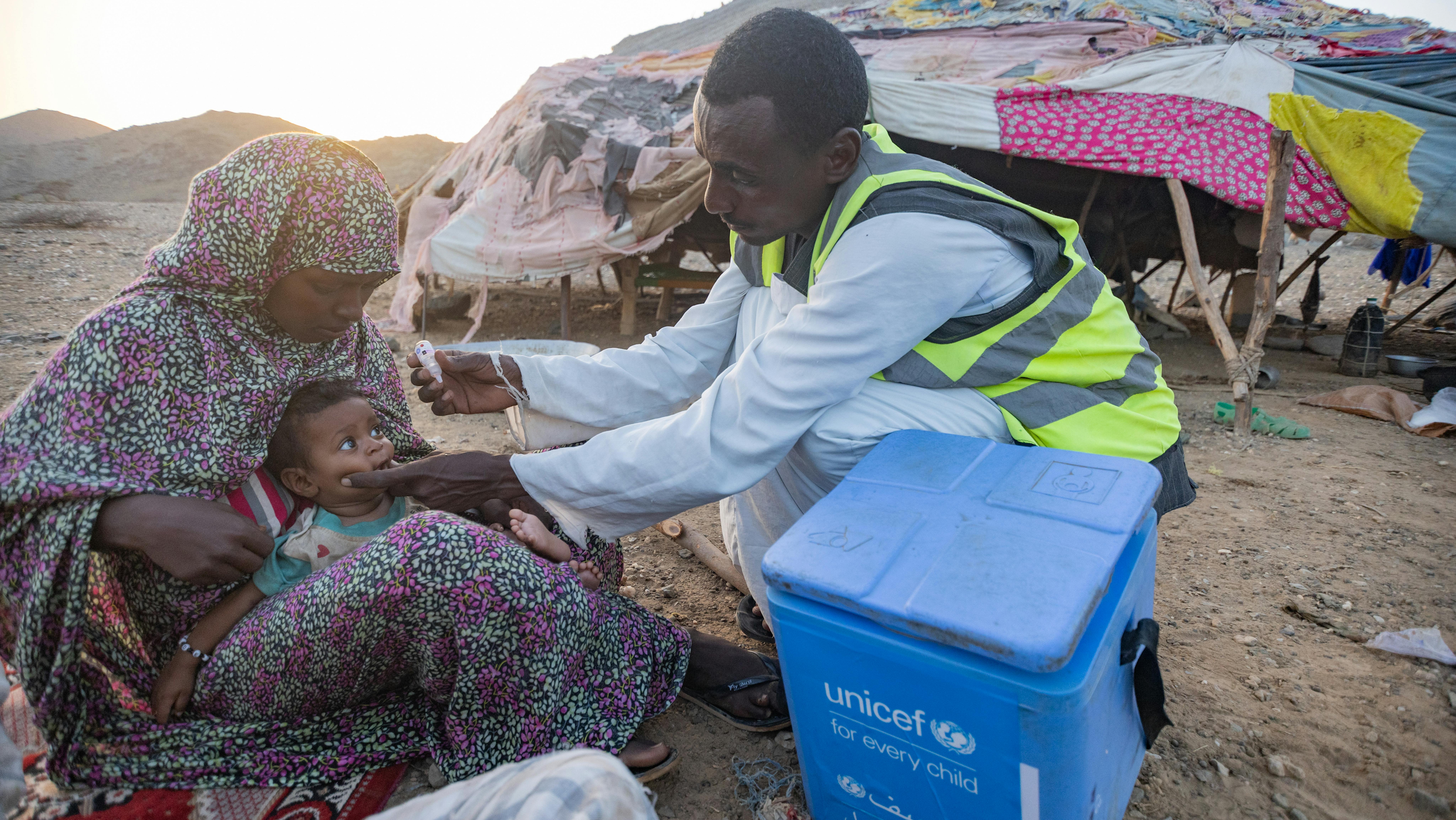 Sudan - Sheeba, un'assistente alle vaccinazioni nella remota località di Agig, nello stato del Mar Rosso, vaccina Orshia di sette mesi contro la poliomielite durante la campagna di vaccinazione antipolio casa per casa.