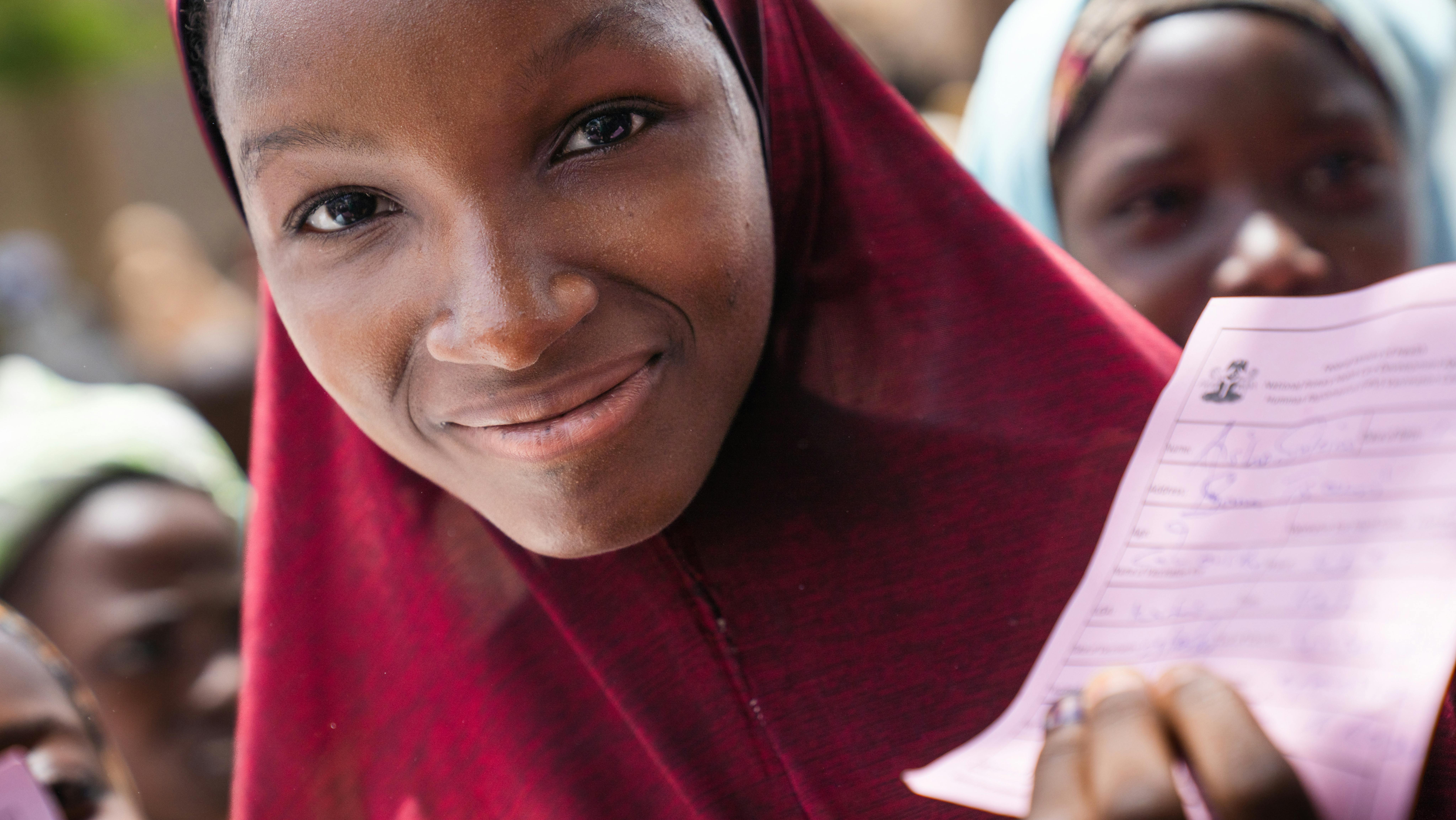 Nigeria - una ragazza mostra la tessera di vaccinazione dopo essere stata vaccinata contro il papillomavirus umano (HPV), in una clinica mobile a Katsina