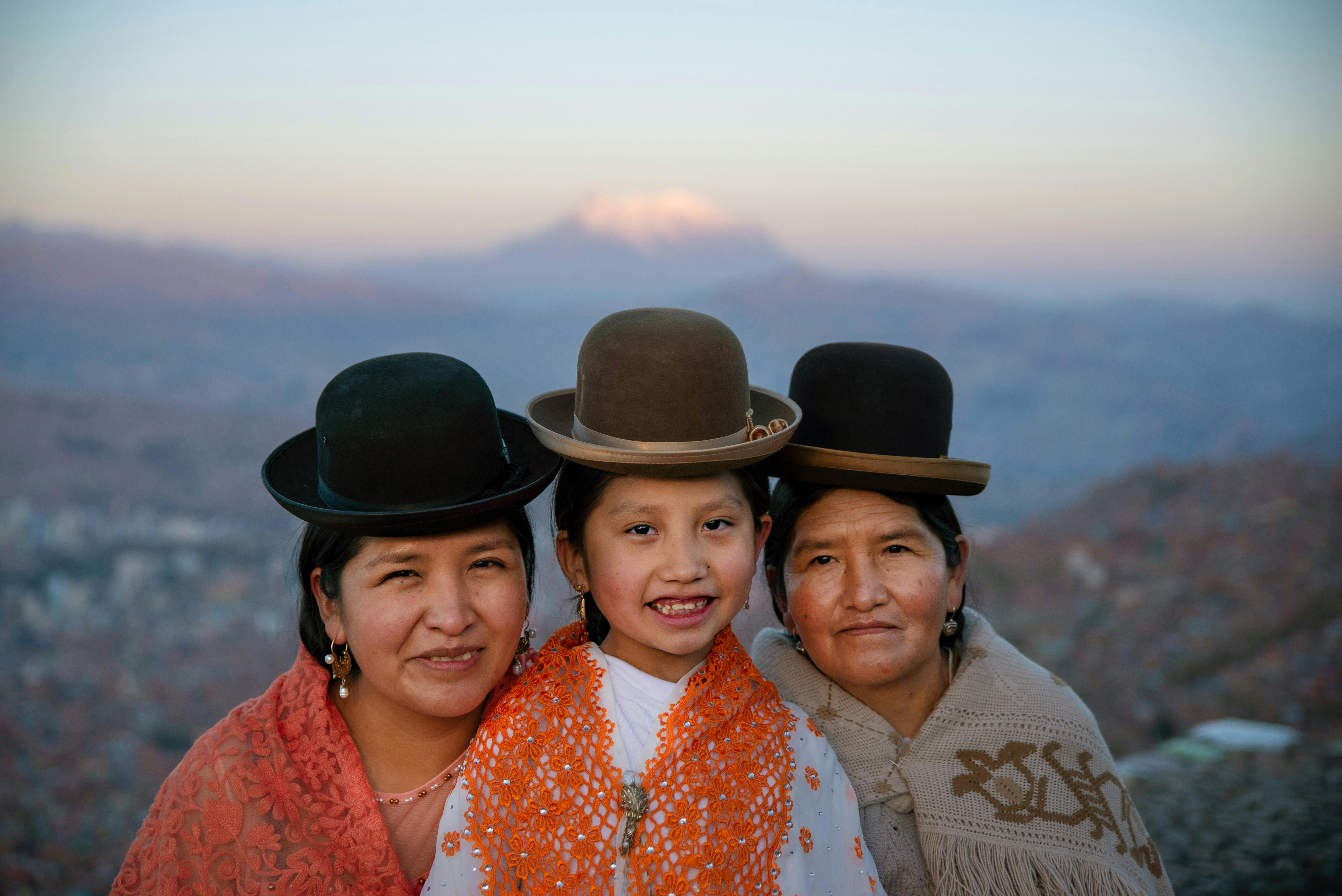 Sandra, Natalhy e Margherita: madre, figlia e nonna sorridono mentre sullo sfondo si vede un meraviglioso paesaggio boliviano