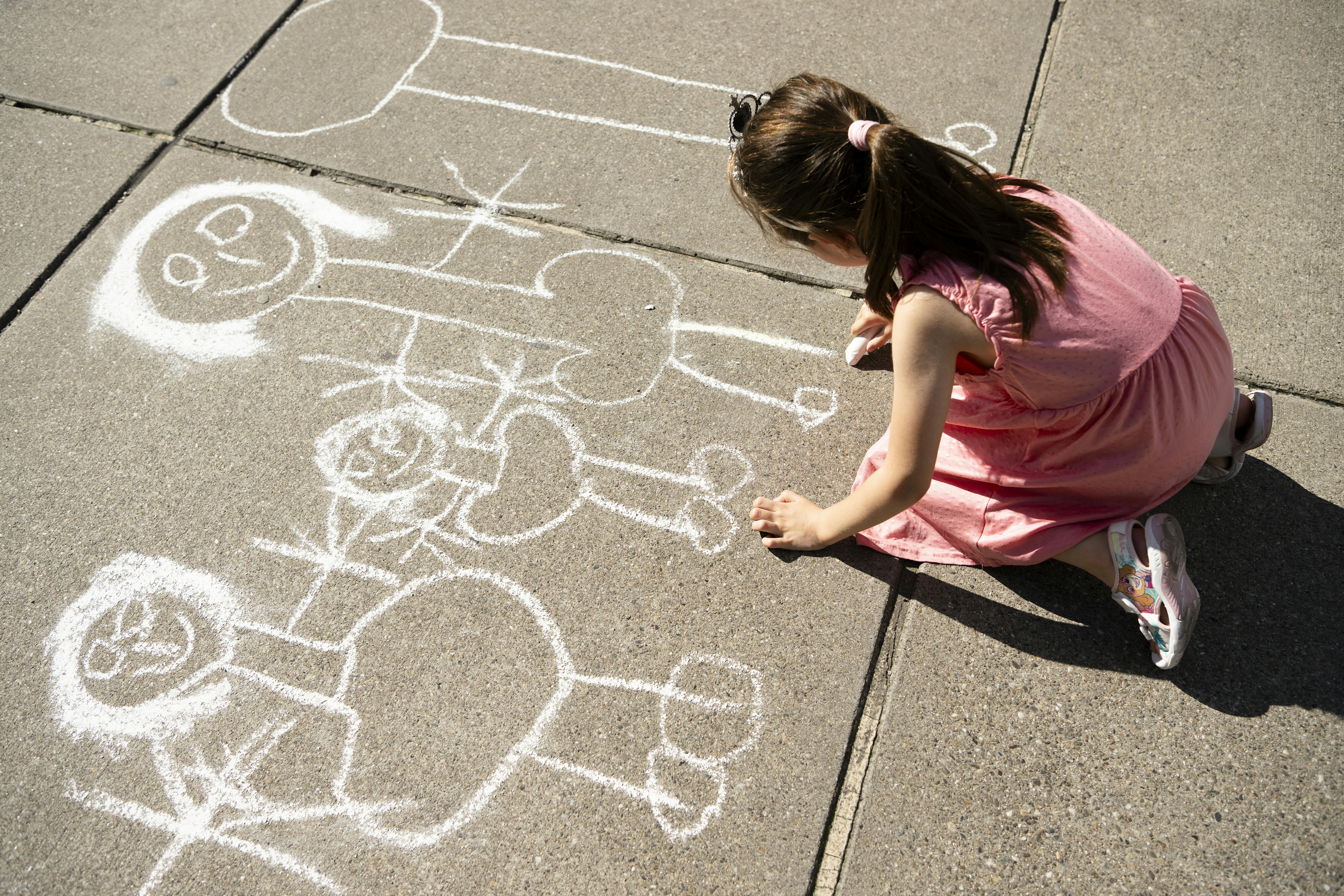 Una bambina disegna con il gesso per terra. Selezione Report Card19
