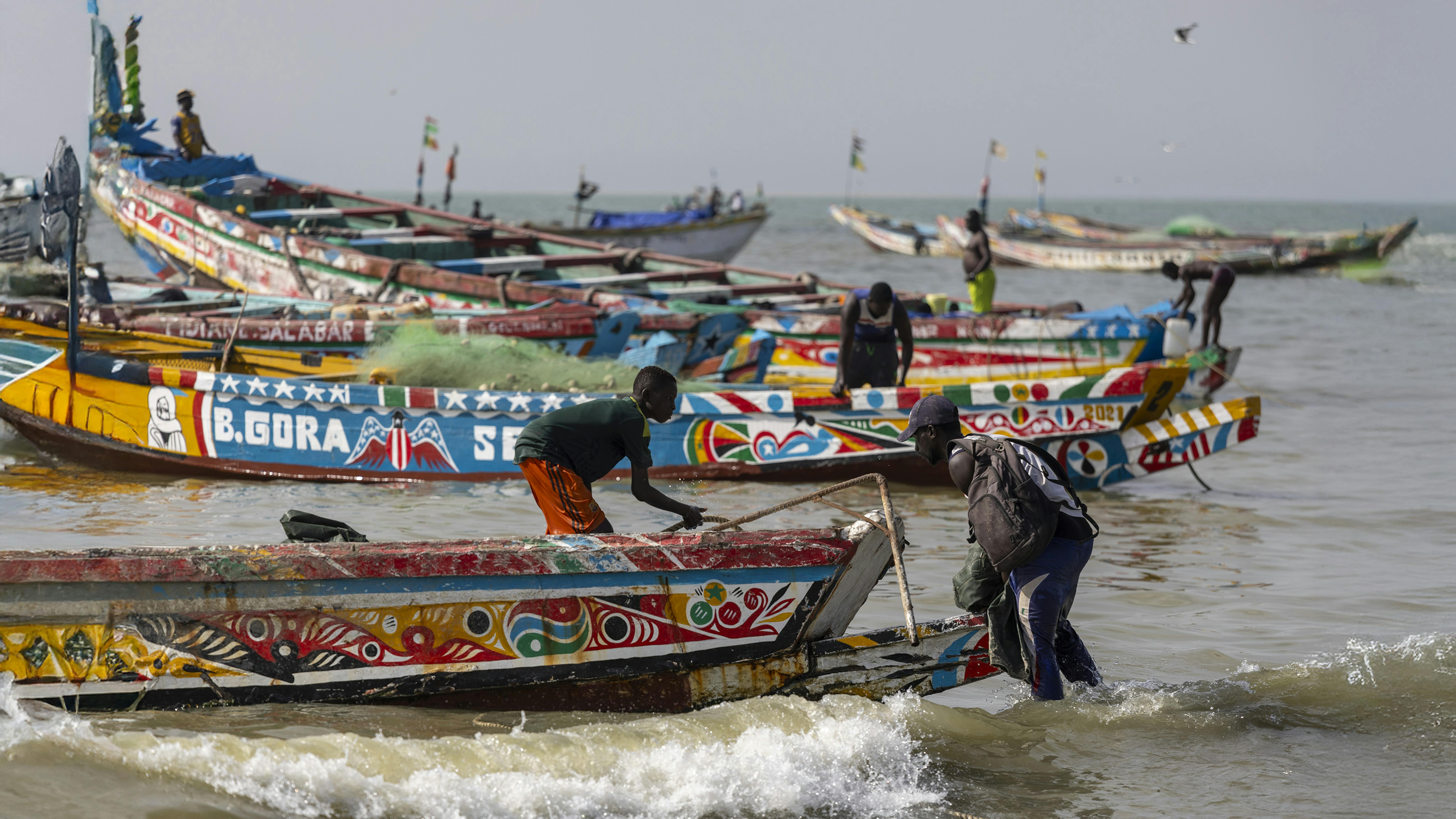 Un ragazzo lavora su una barca da pesca sulla spiaggia di Tanji, in Gambia, il 17 febbraio 2024. Foto UNICEF/Karel Prinsloo