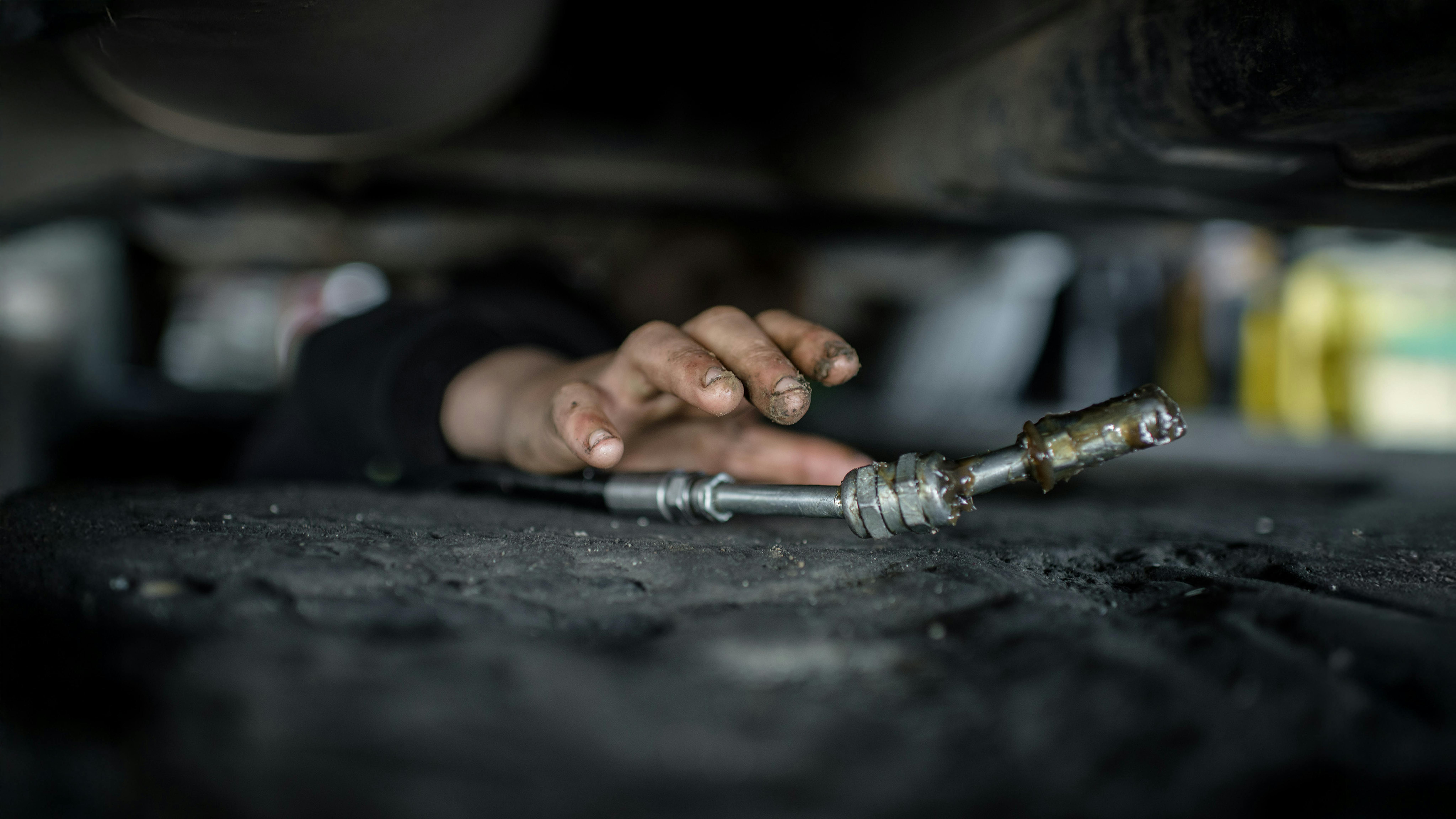 Mohammed, 14 anni, un rifugiato siriano di Kobane, lavora sotto un'auto in un'officina di riparazione a Erbil, nella regione del Kurdistan iracheno, il 10 marzo 2016.