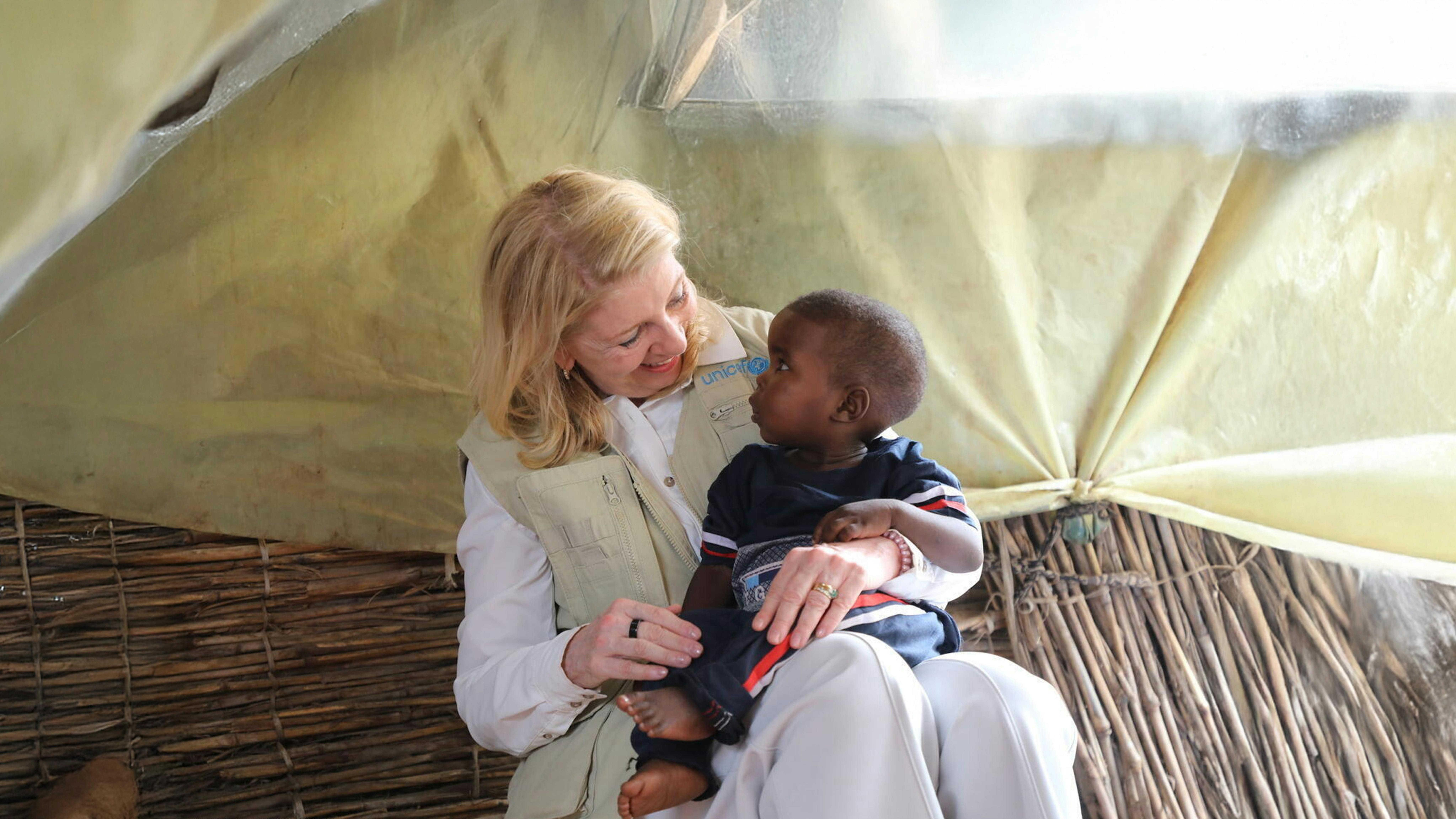 ad Adré, in Ciad, la Direttrice esecutiva dell'UNICEF Catherine Russell interagisce con un giovane sudanese, trovato non accompagnato e affidato in affido a una donna ciadiana di nome Amina Kabir (non nella foto).