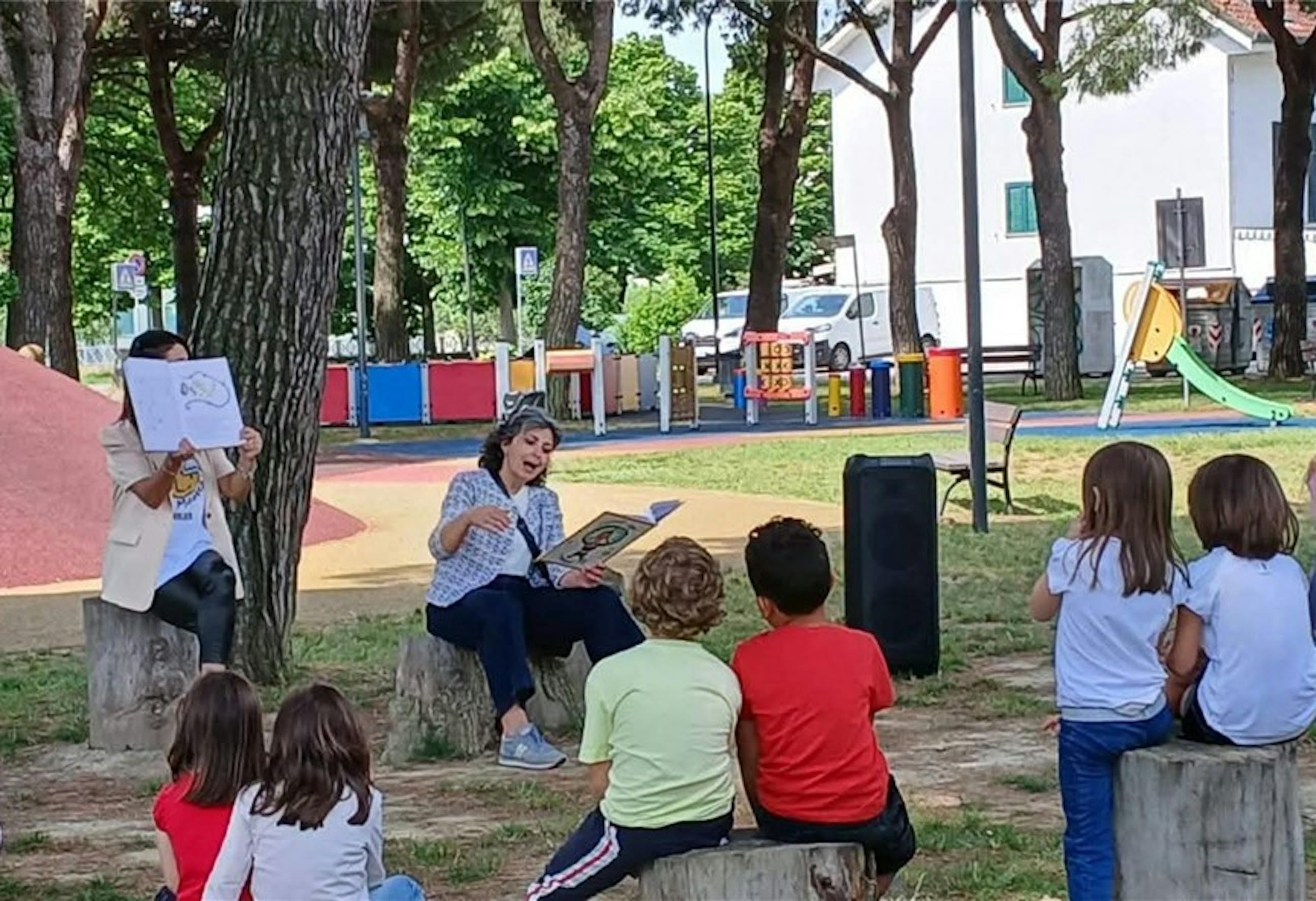 Ravenna, un gruppo di bambini assiste a una lettura all'aperto durante le giornate dedicate al Diritto al Gioco di UNICEF