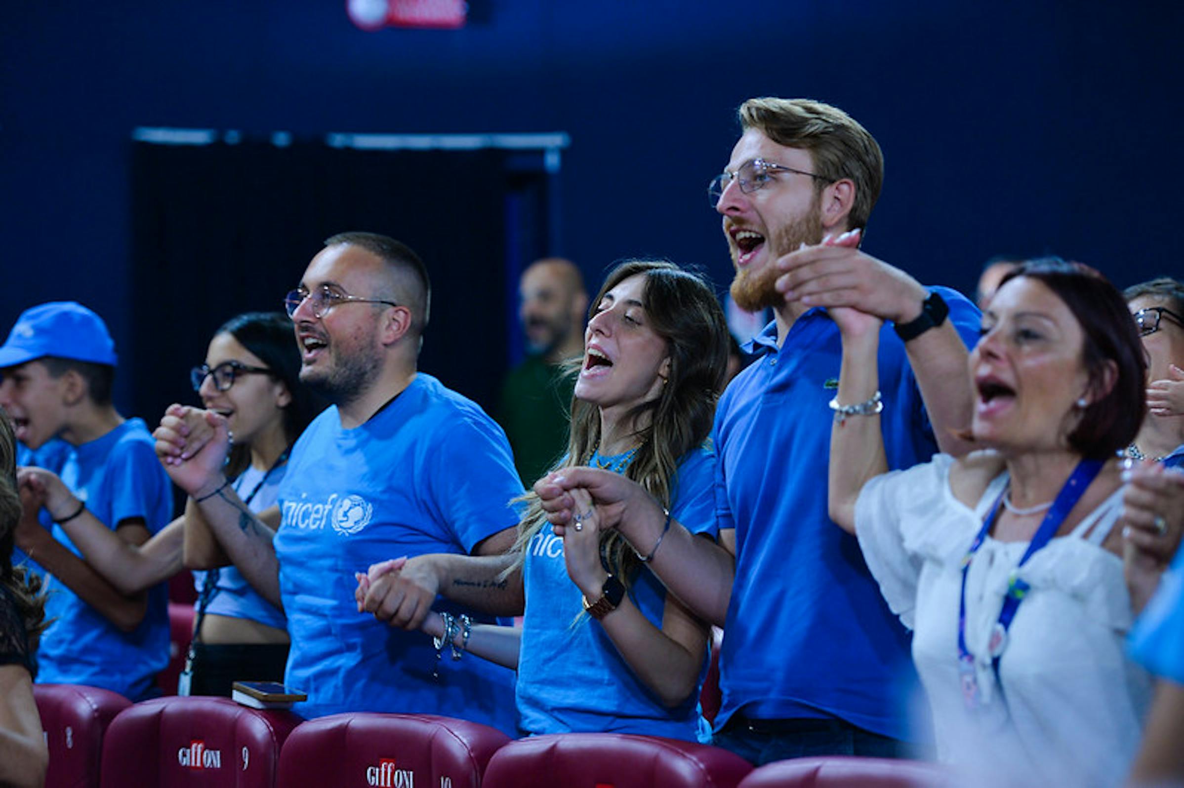 La platea di spettatori si alza in piedi all'appello del Portavoce UNICEF Andrea Iacomini per la pace