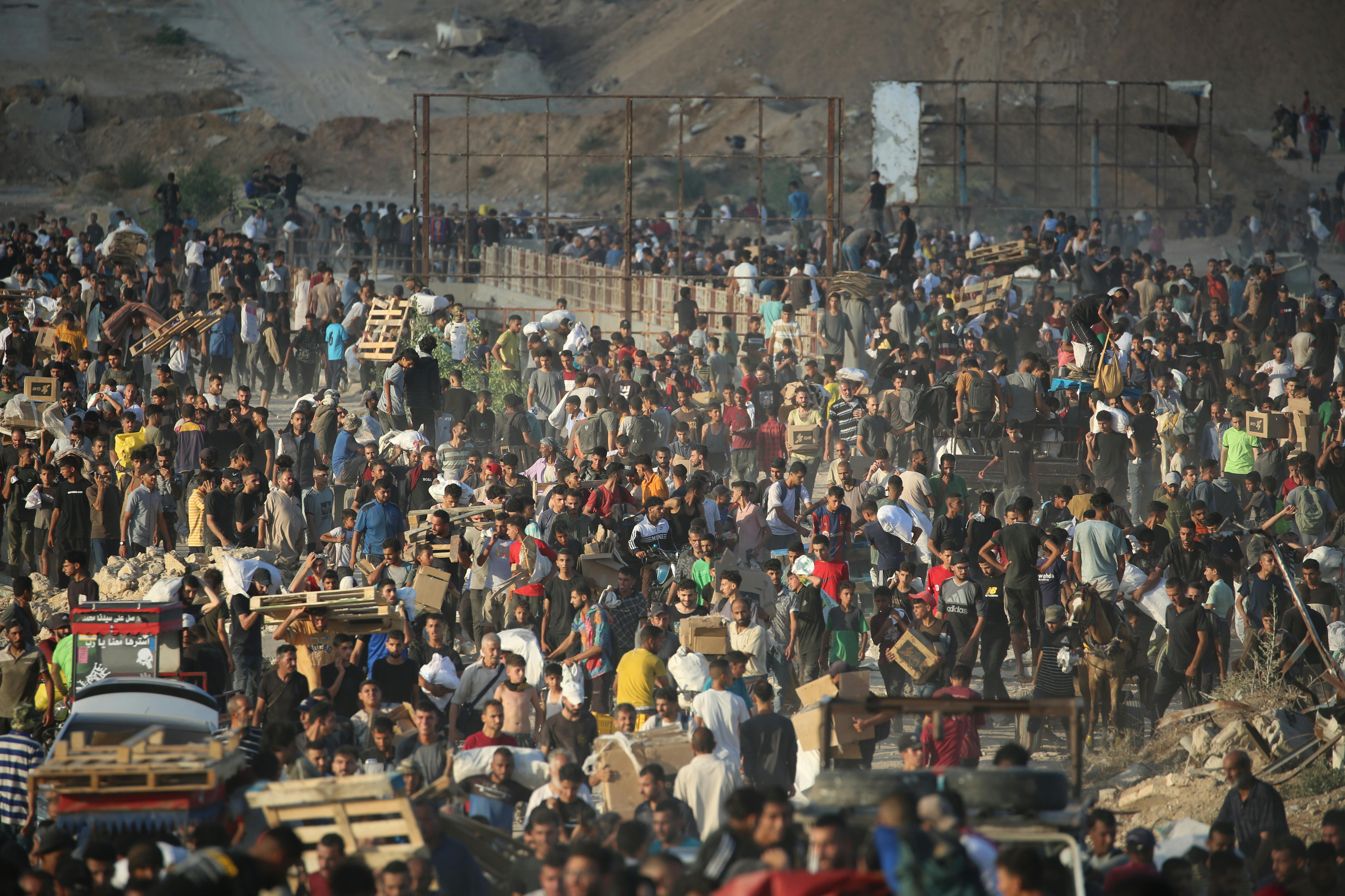 Una folla di persone in fila a Netzarim, una strada che taglia in due la Striscia di Gaza dove la Gaza Humanitarian Foundation sta distribuendo aiuti umanitari