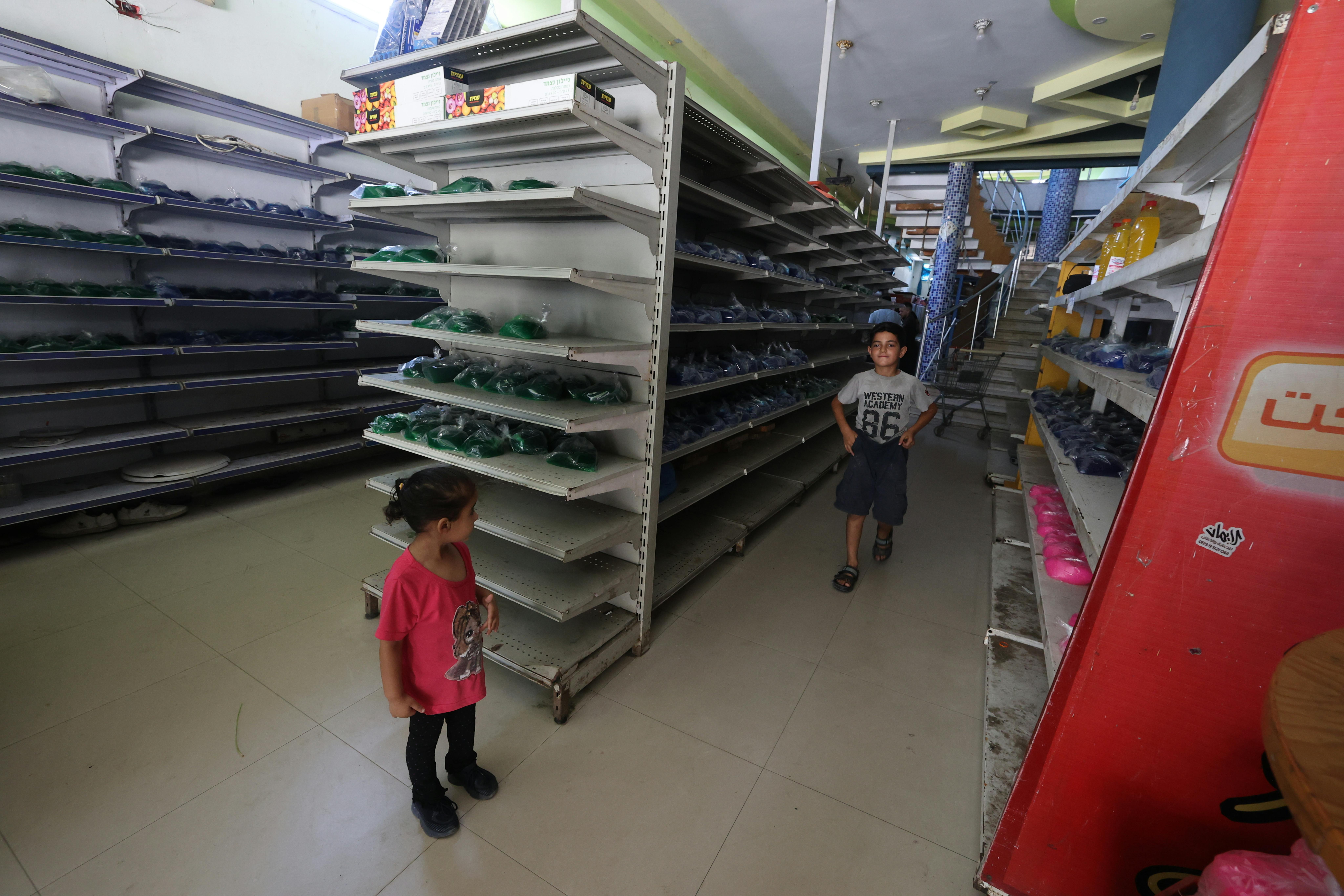 Gaza City: due bambini si muovono tra gli scaffali vuoti di un mini market. Il paese sta affrontando una grave carestia a causa del conflitto