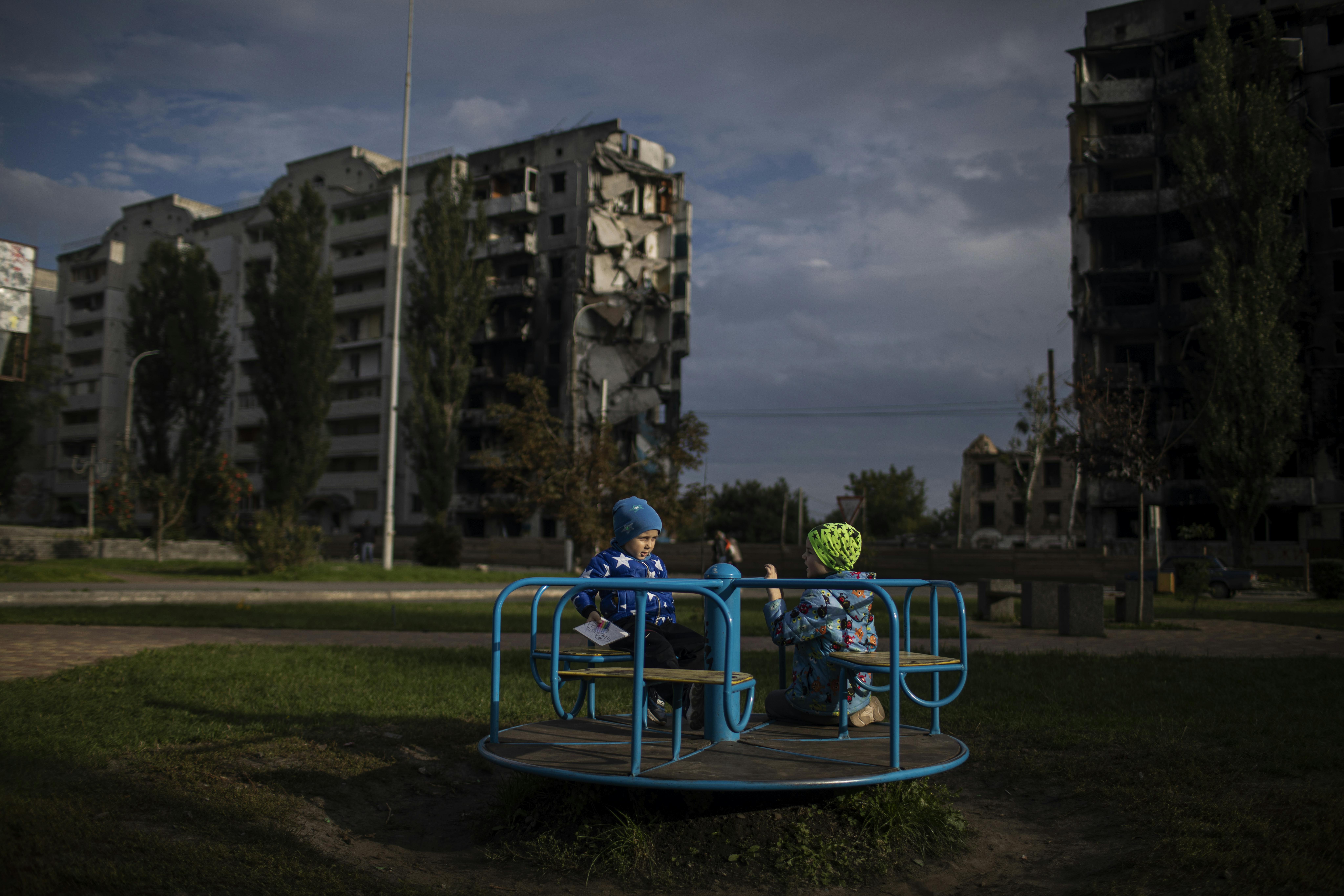 Il 29 settembre 2022, in Ucraina, i bambini giocano sullo sfondo di edifici distrutti a Borodyanka. La città, che ha visto feroci combattimenti nei primi giorni dell'escalation della guerra, mostra i segni di intensi bombardamenti. Oltre il 90% del centro città è stato distrutto.