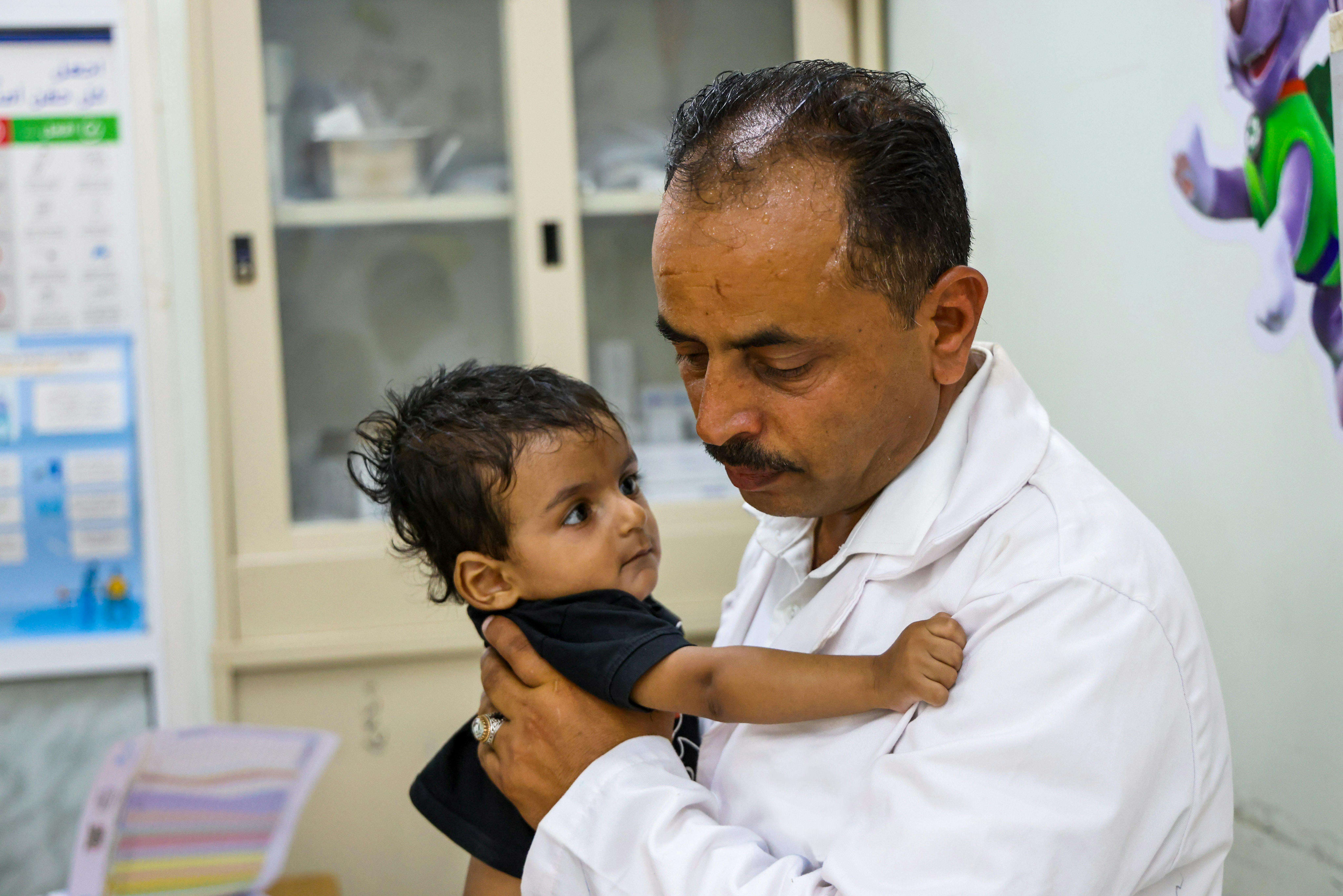 Hamad, nove mesi, con il dottor Abdulsalam Haidar, capo dell'unità di nutrizione a Taizz, in Yemen