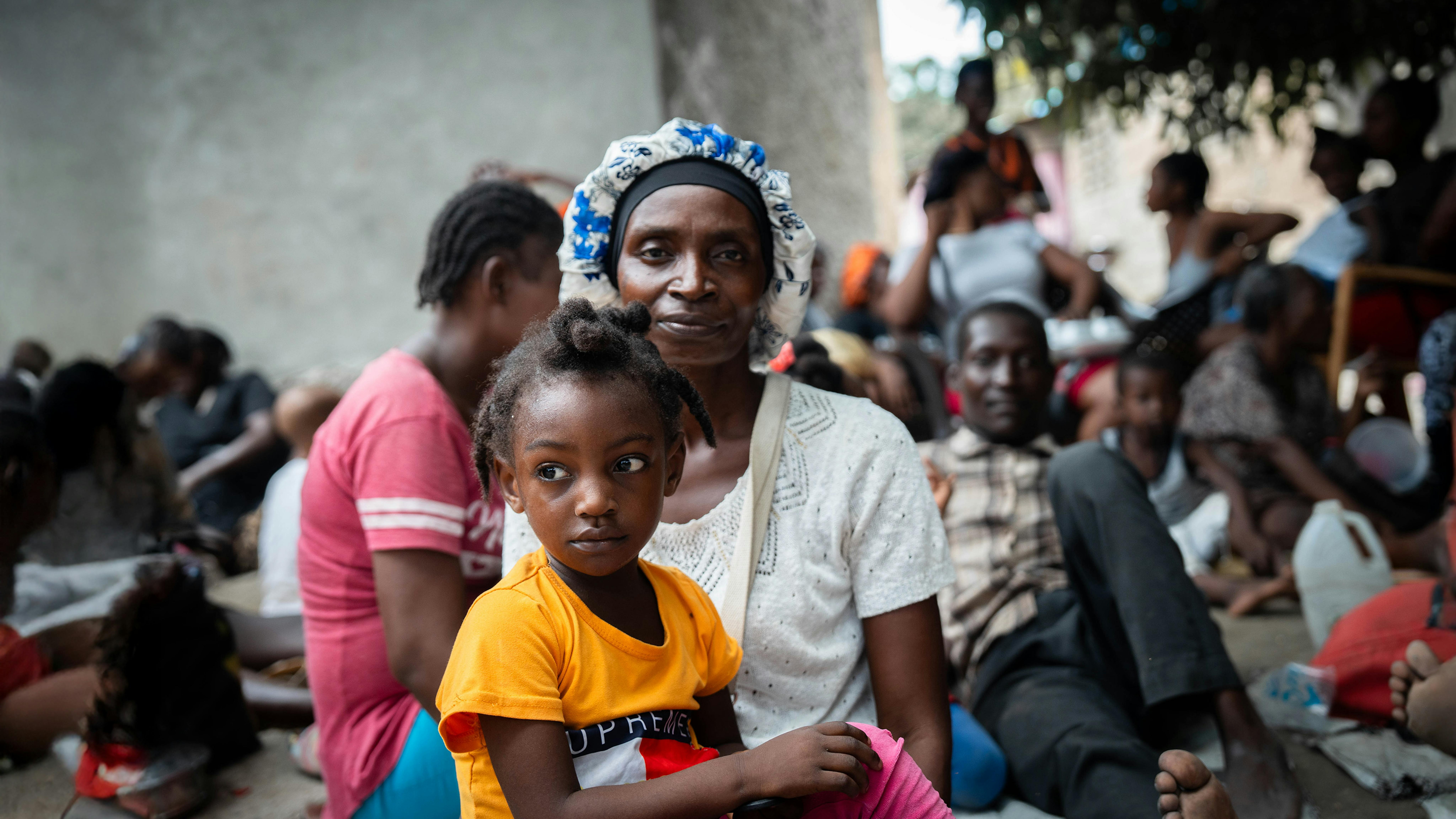 Haiti - Una madre sfollata di recente tiene in braccio il suo bambino in un sito di sfollamento improvvisato.