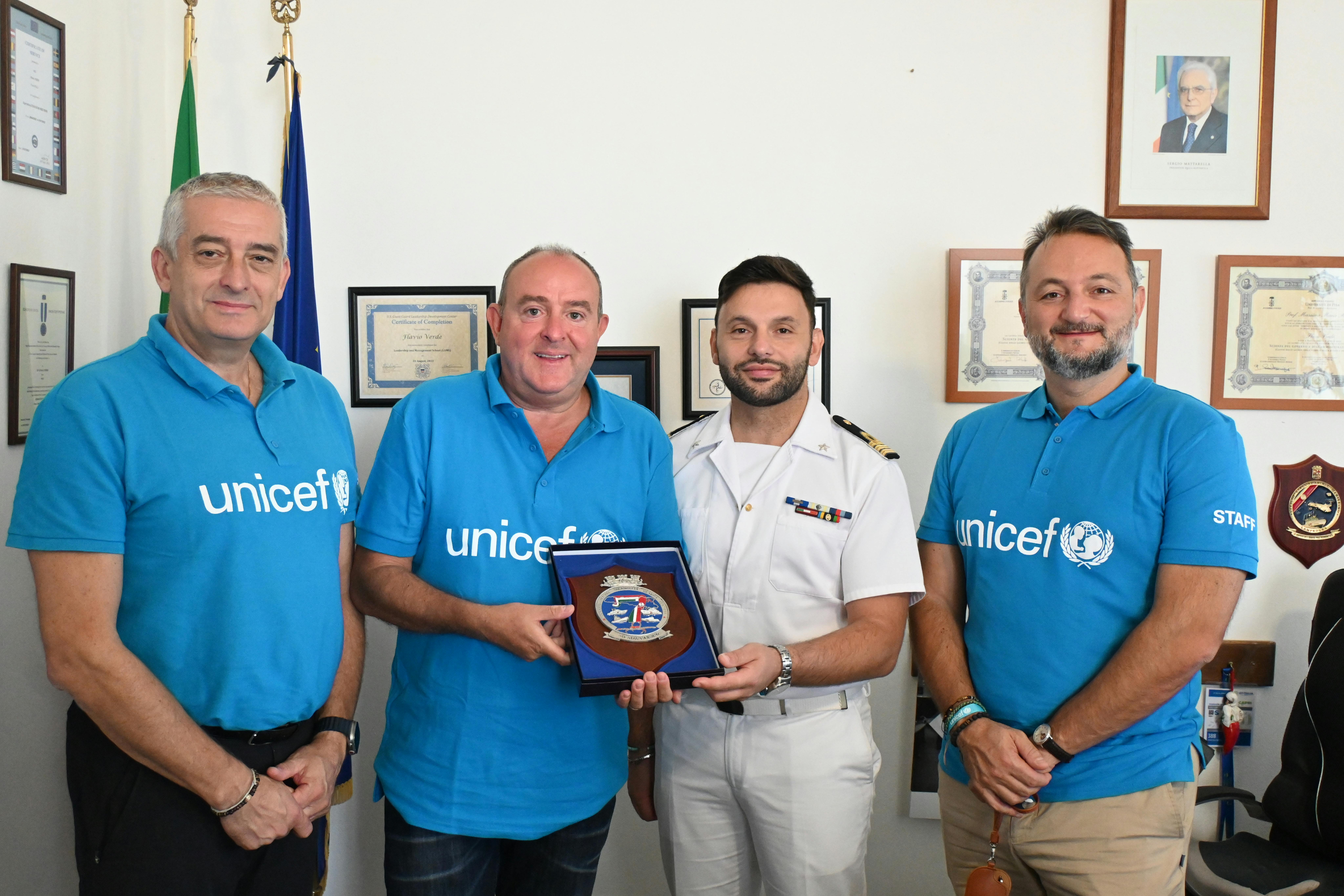 Il tenente Flavio Verde consegna una targa al Presidente dell'UNICEF Italia Nicola Graziano. A sinistra, il Direttore Generale Paolo Rozera; a destra, Nicola Dell’Arciprete, Coordinatore della risposta rifugiati e migranti.