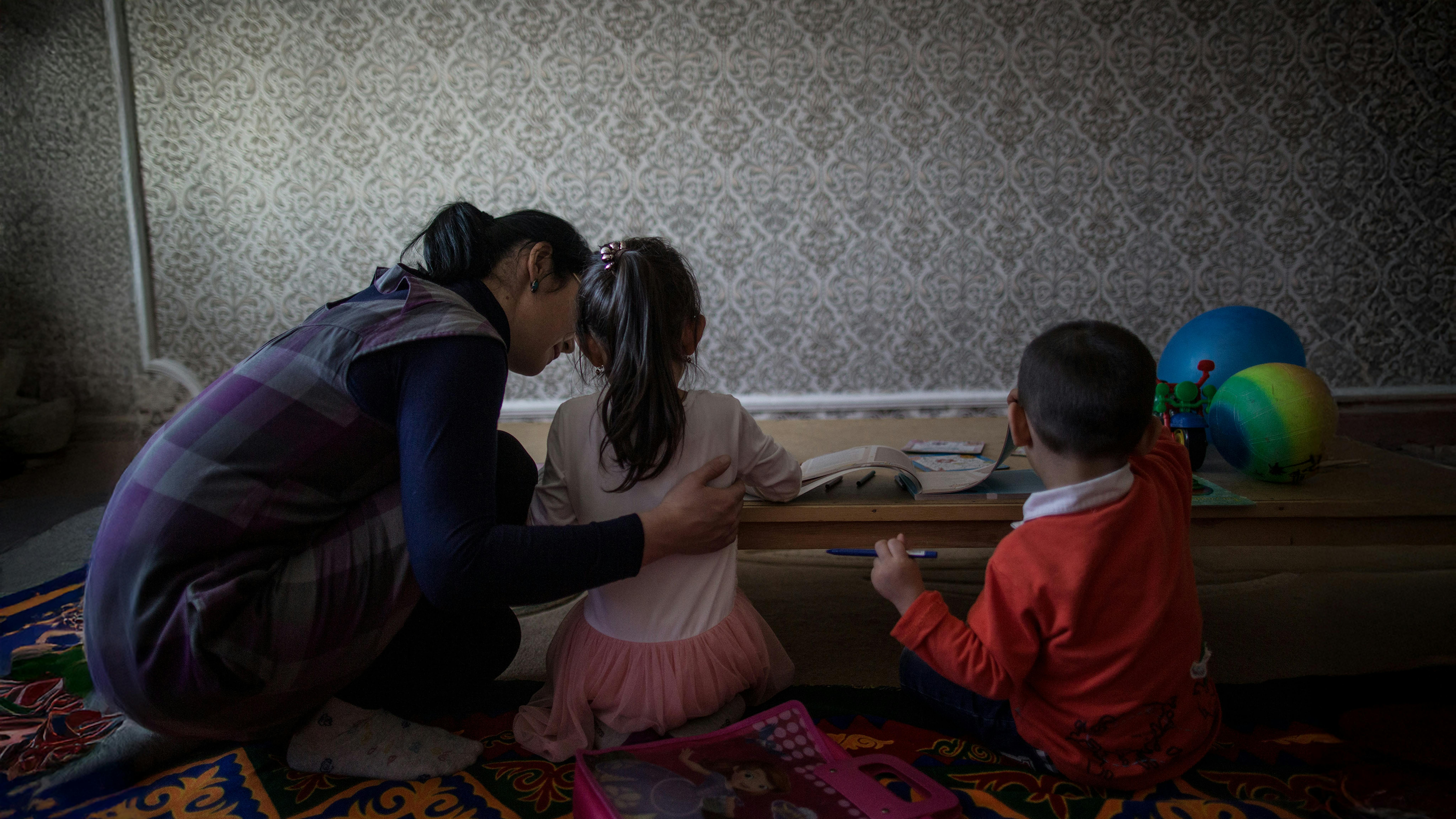 L'infermiera Dinara Akhmetova gioca con Anelya, 5 anni, e Arsen, 3 anni, nel soggiorno dell'appartamento della famiglia dei bambini a Kyzylorda, in Kazakistan, il 12 marzo 2018.