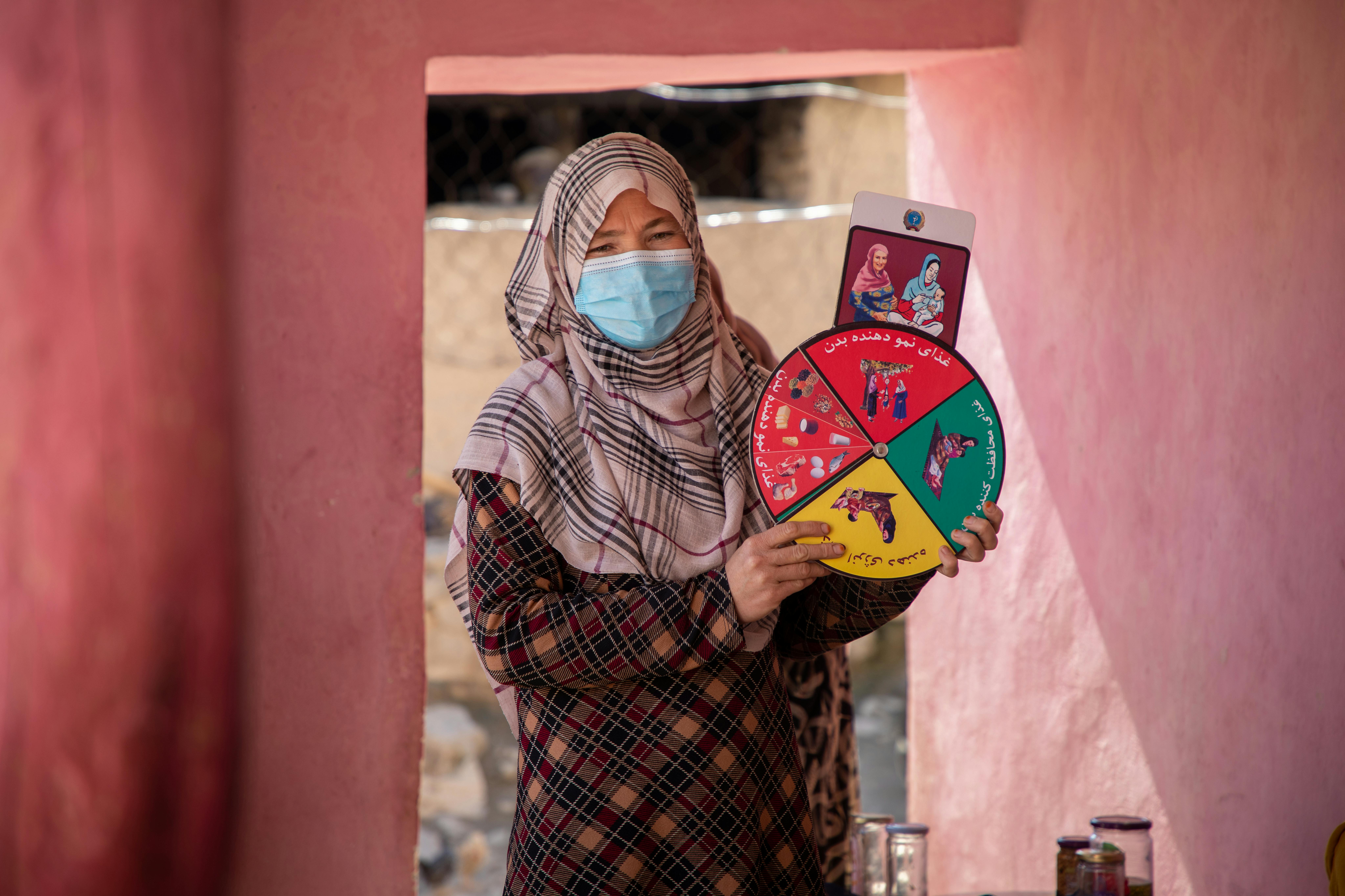 Farzia, 29 anni, spiega il piano alimentare nutrizionale preventivo alle madri presso il Bochi Health Post nel villaggio di Bochi, in Afghanistan.