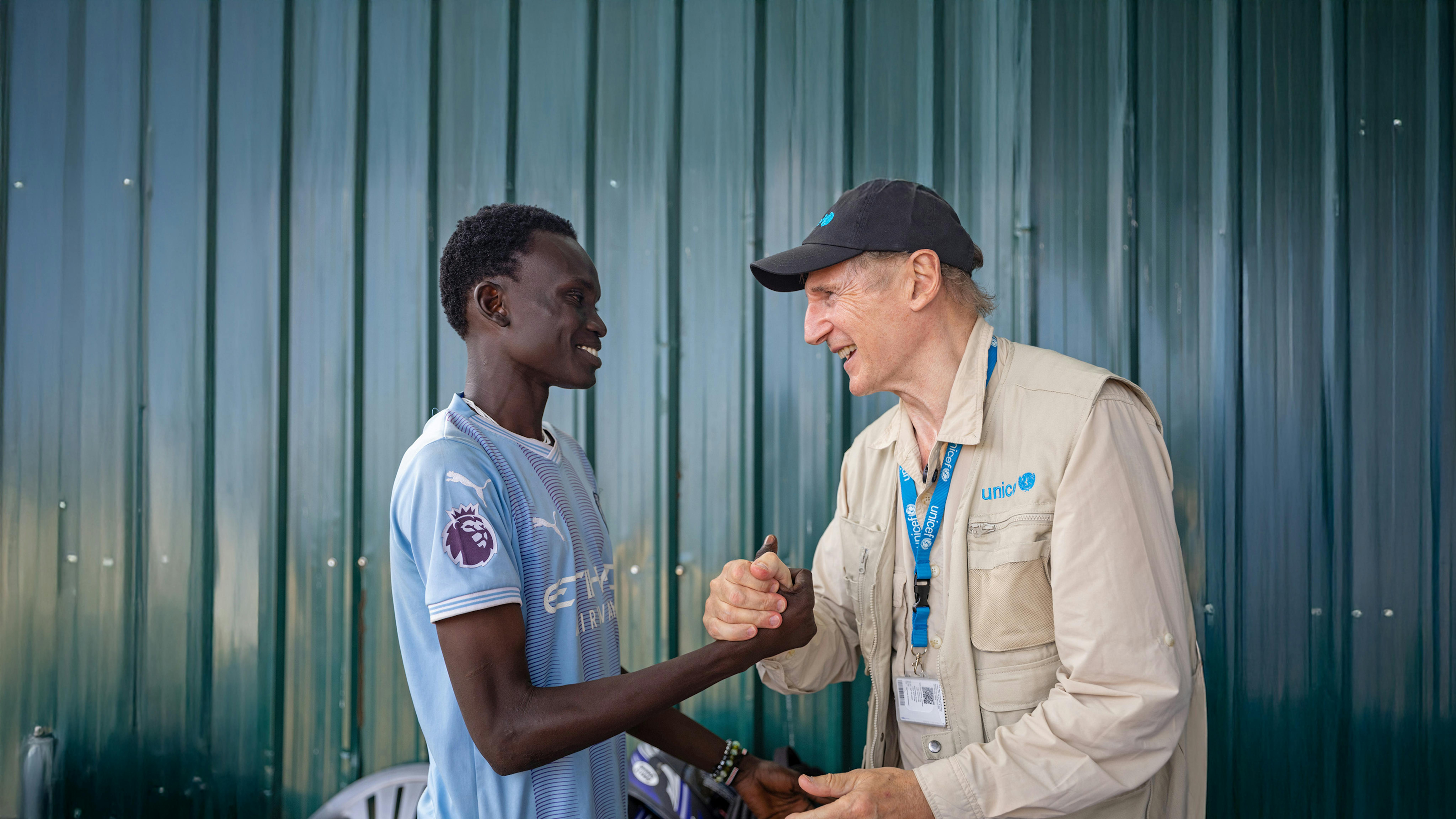 L'Ambasciatore di buona volontà dell'UNICEF, Liam Neeson, incontra Alan, 20 anni, al Centro Giovanile di Gredo a Juba, Sud Sudan
