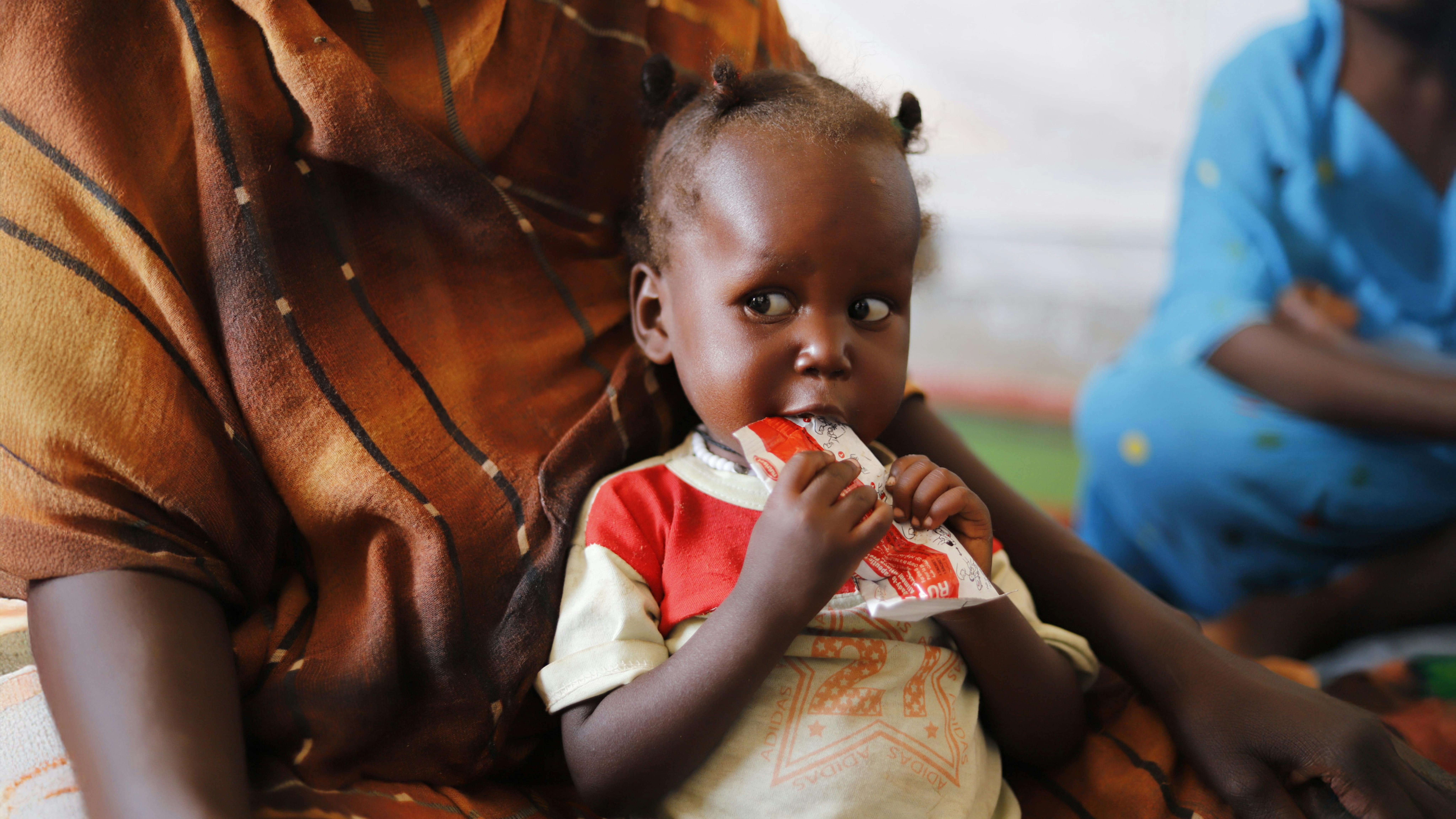 Sudan - Il 4 maggio, un bambino che soffre di malnutrizione mangia cibo terapeutico pronto all'uso in una clinica di salute primaria supportata dall'UNICEF a Tawila, nel Nord Darfur.