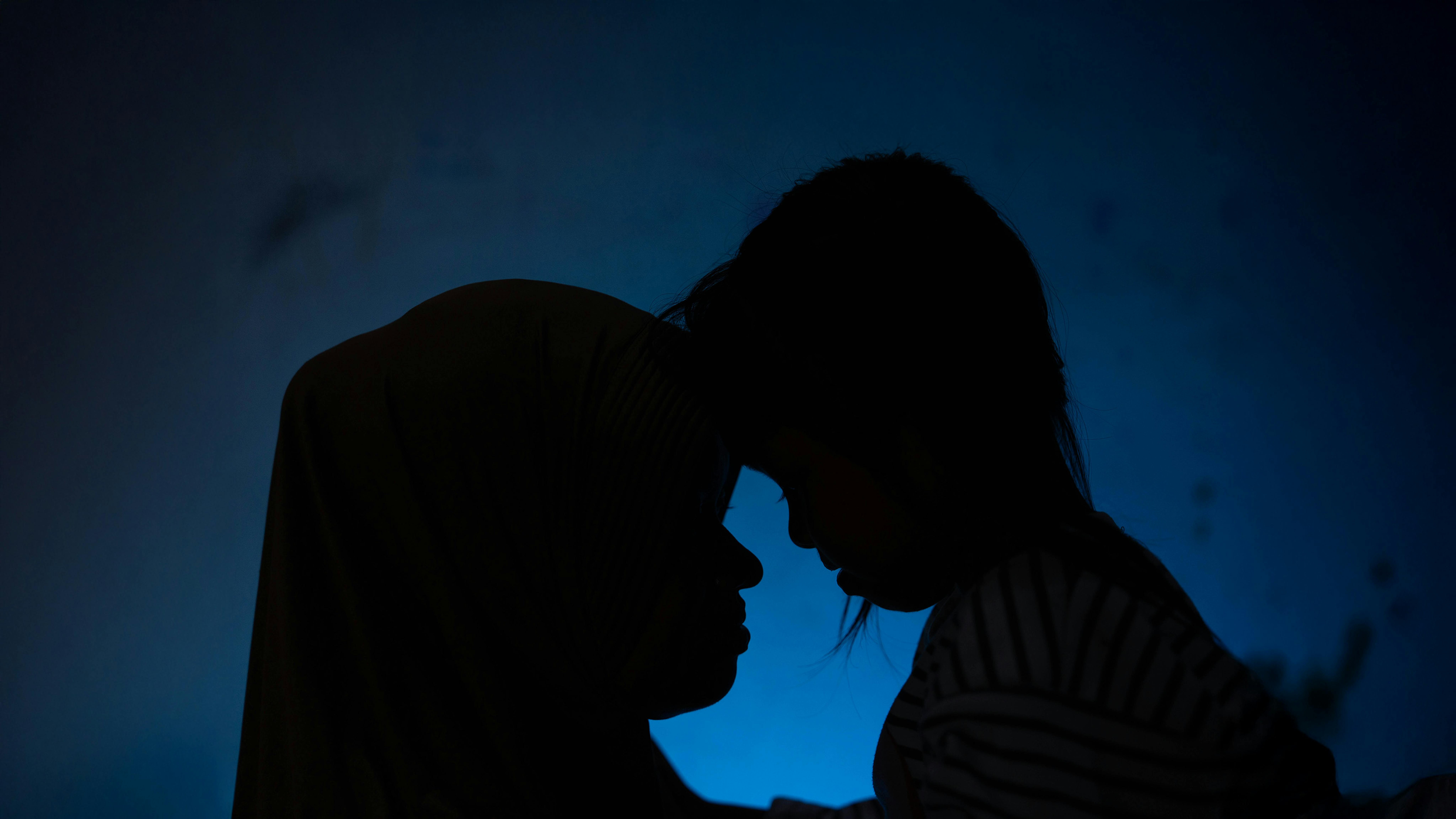 (da sinistra a destra) Hani (nome cambiato) e sua figlia, Kusuma, 8 anni, appoggiano la testa l'una sull'altra nella loro casa a Klaten, nella provincia di Giava Centrale