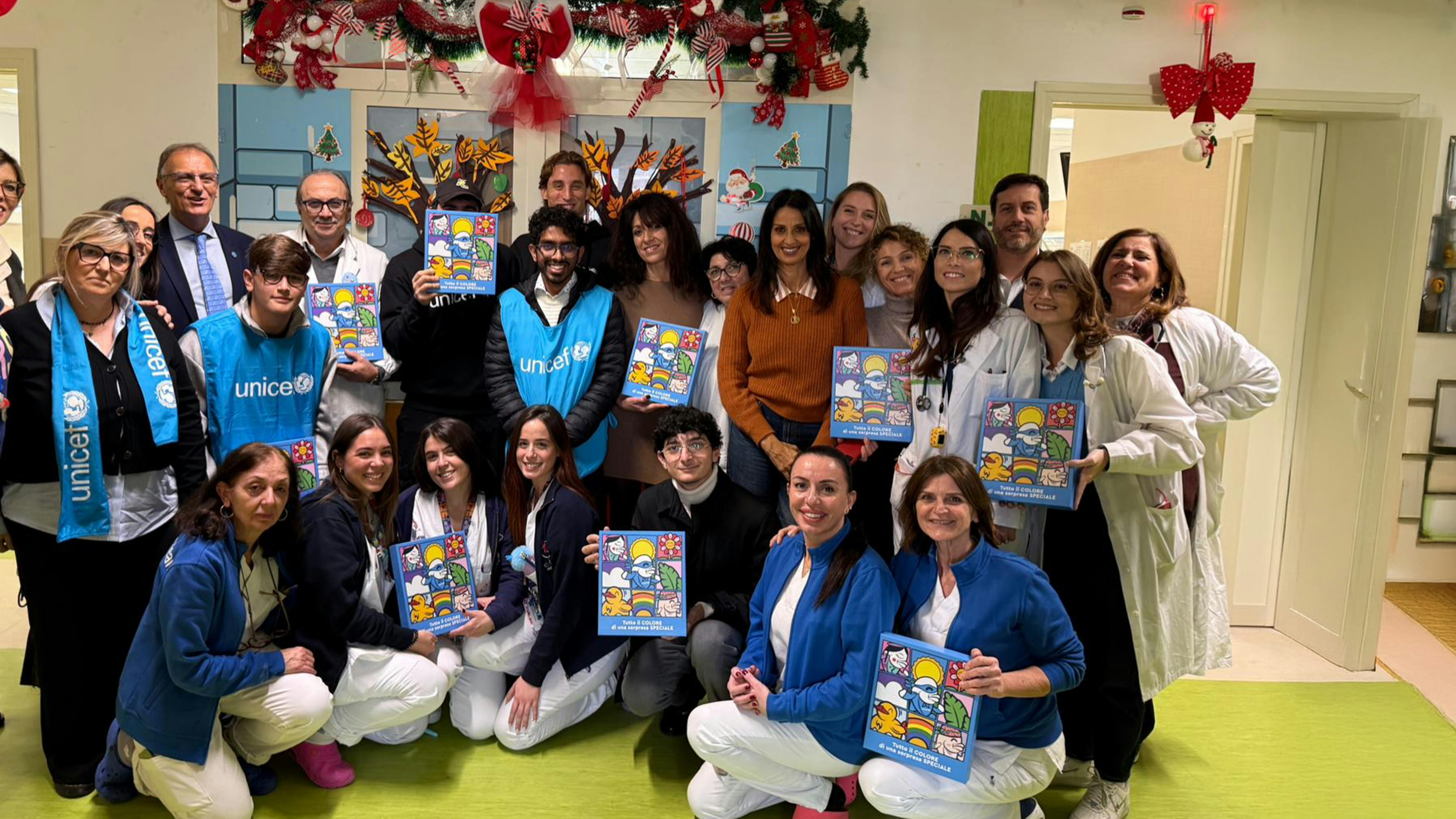 Foto di gruppo dello staff UNICEF e dell'Ospedale Santobono Pausipolon con le confezioni dei regali sospesi.  Il terzo da sinistra Pierpaolo Clementoni, al centro in fondo il calciatore Edoardo Bove e il penultimo a destra il Portavoce UNICEF Italia Andrea Iacomini
