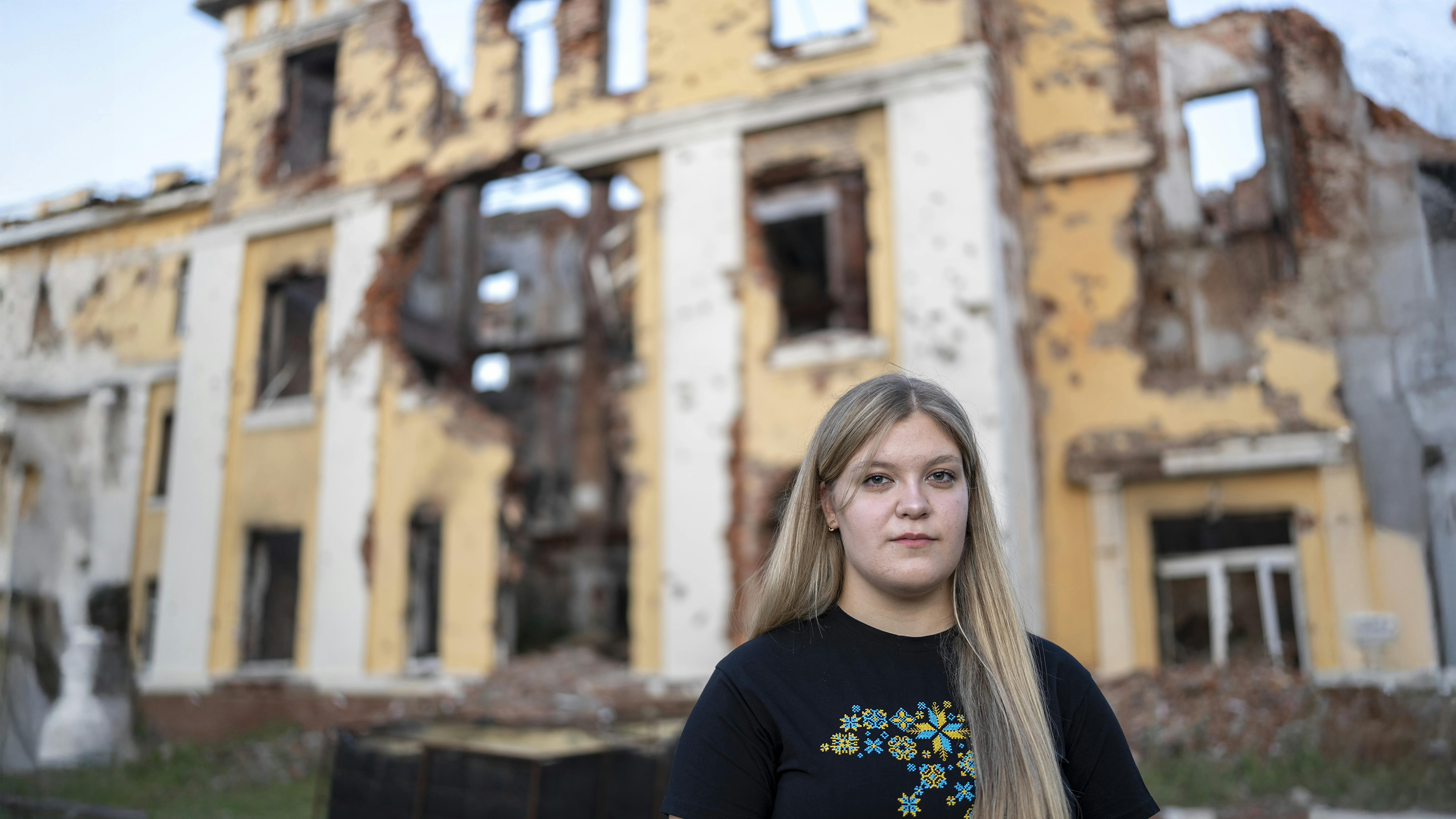 Sofiia, 17 anni, si trova davanti alla facciata gravemente danneggiata della sua ex scuola a Kharkiv, nel nord-est dell'Ucraina.