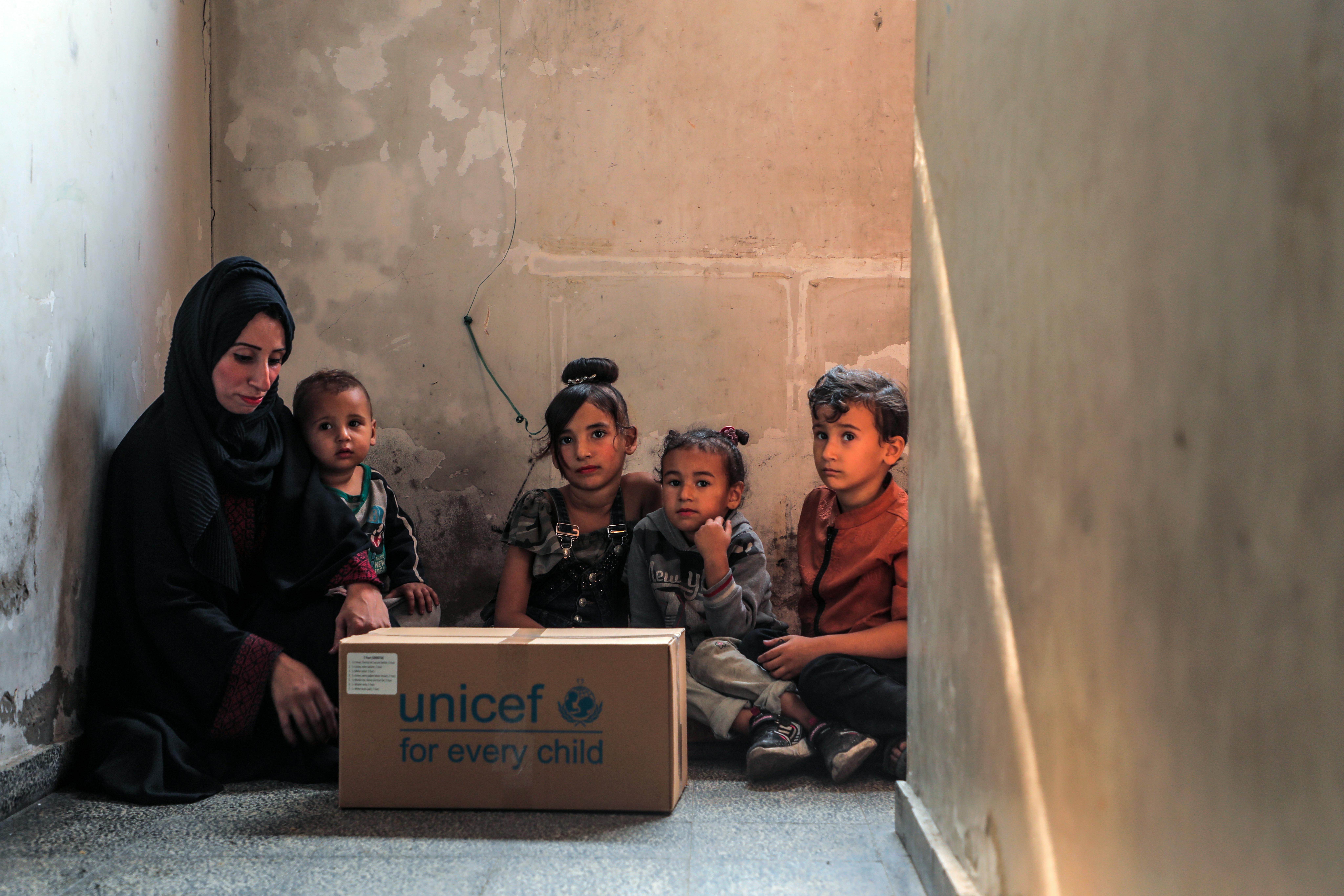 Woroud, si trova con i suoi figli in un edificio abbandonato dove sono rifugiati. Hanno appena ricevuto un pacco UNICEF con indumenti caldi per i bambini