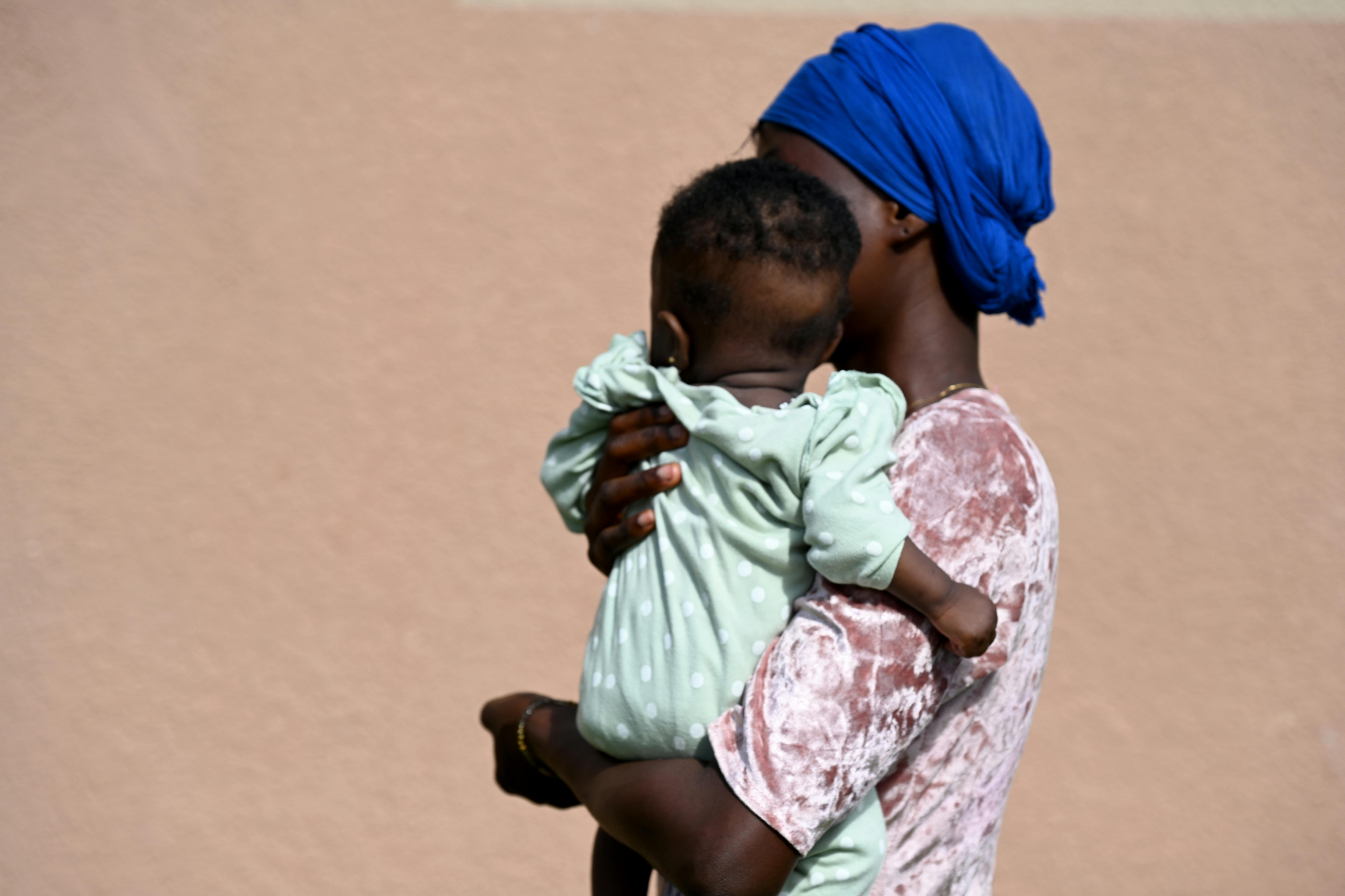 Costa d'Avorio: Amy, una giovane mamma di 21 anni tiene in braccio la piccola Odienné, entrambe in cura a causa della positività all'HIV