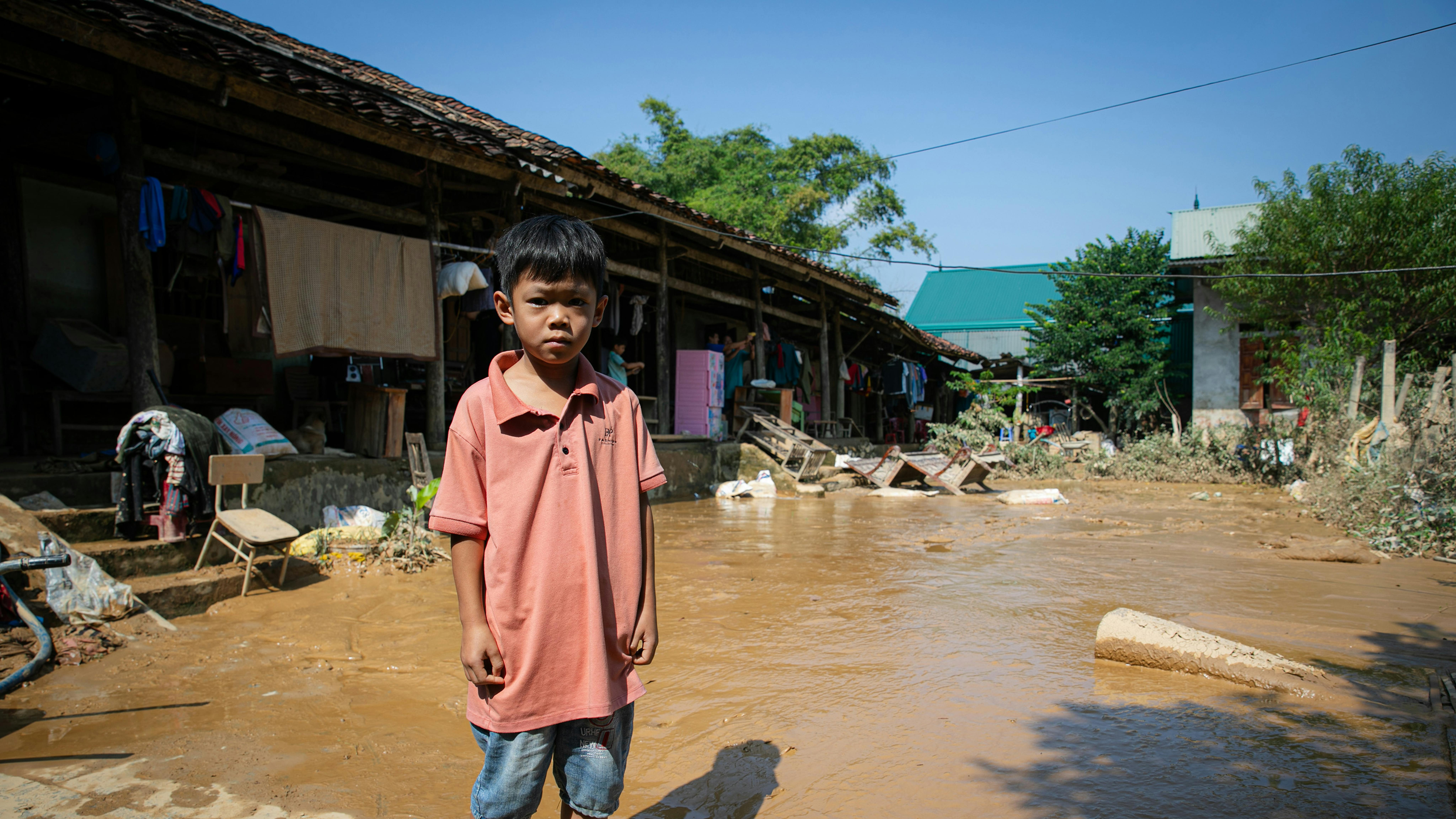 Tạ Minh Khang, 7 anni, popolazione etnica Nùng nel comune di Hoà An, provincia di Cao Bằng.  La casa di Khang era quasi completamente allagata, così lui e la sua famiglia dovettero trasferirsi nella casa della nonna su un terreno più alto