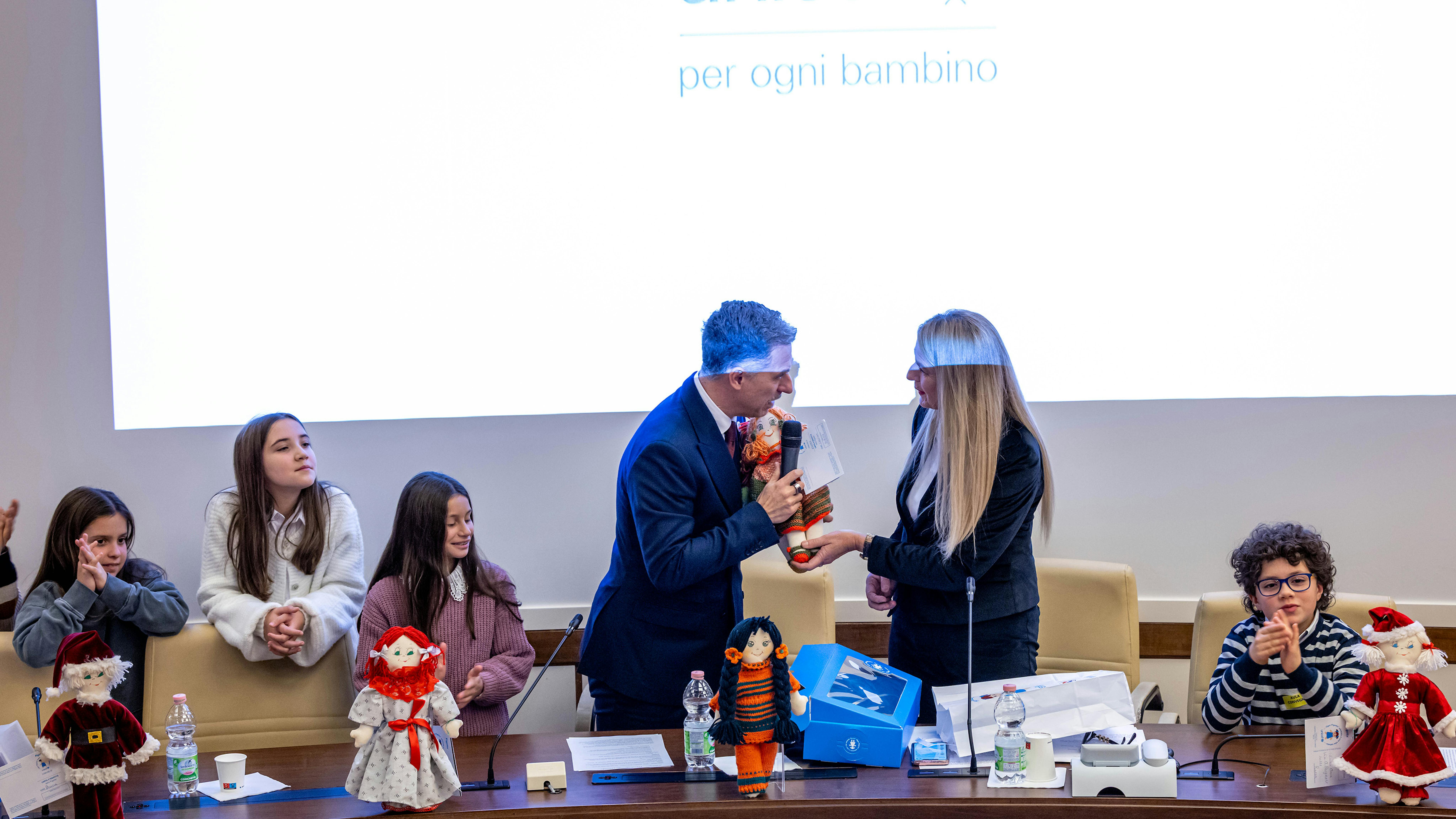 L’Ambasciatore dell’UNICEF Italia Gabriele Corsi consegna la Pigotta alla Presidente della Commissione straordinaria per la tutela e la promozione dei diritti umani Stefania Pucciarelli