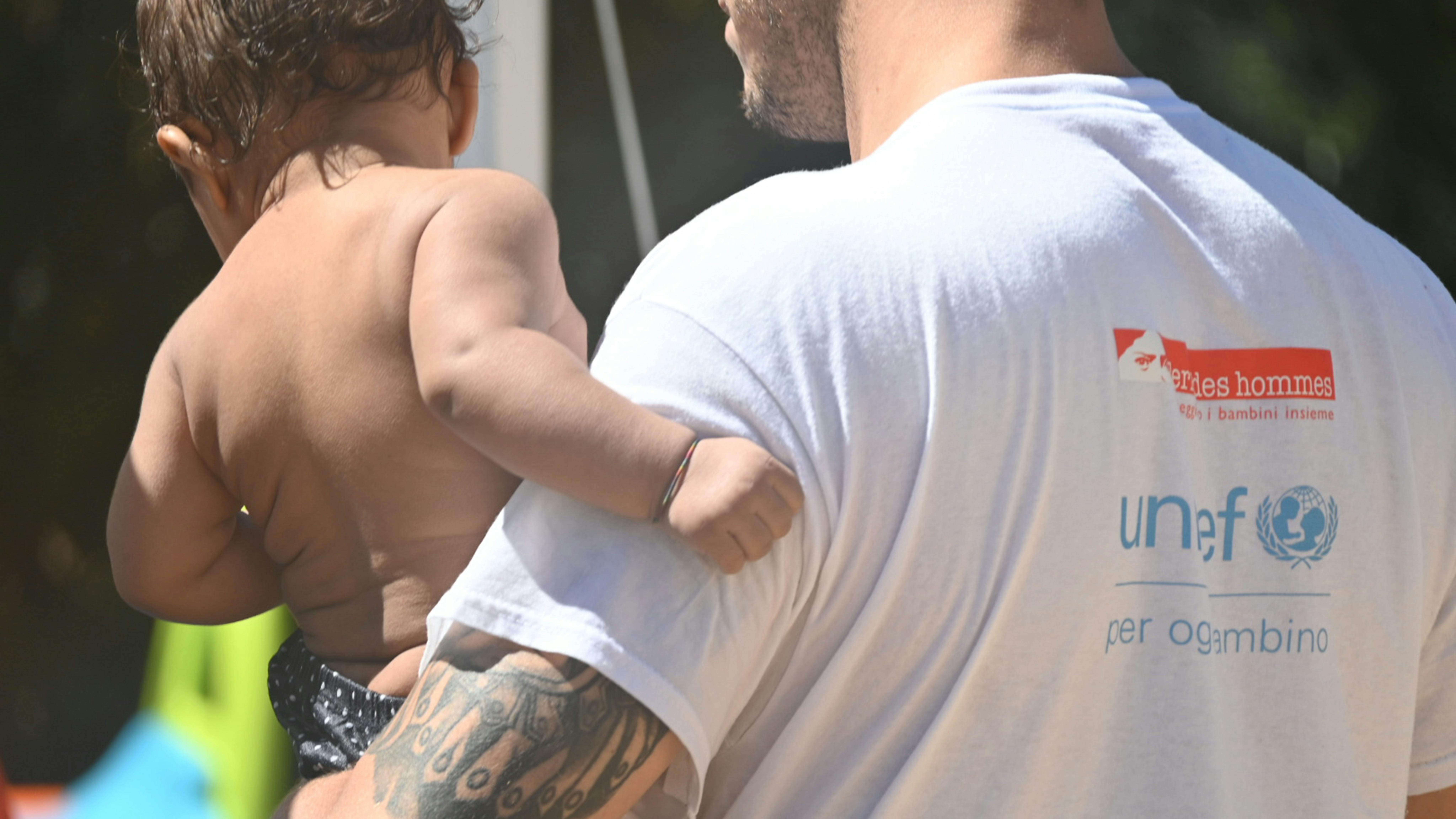 Un operatore insieme a un bambino ospite di un centro d’accoglienza in Sud Italia. © UNICEF/Saturnino/2025
