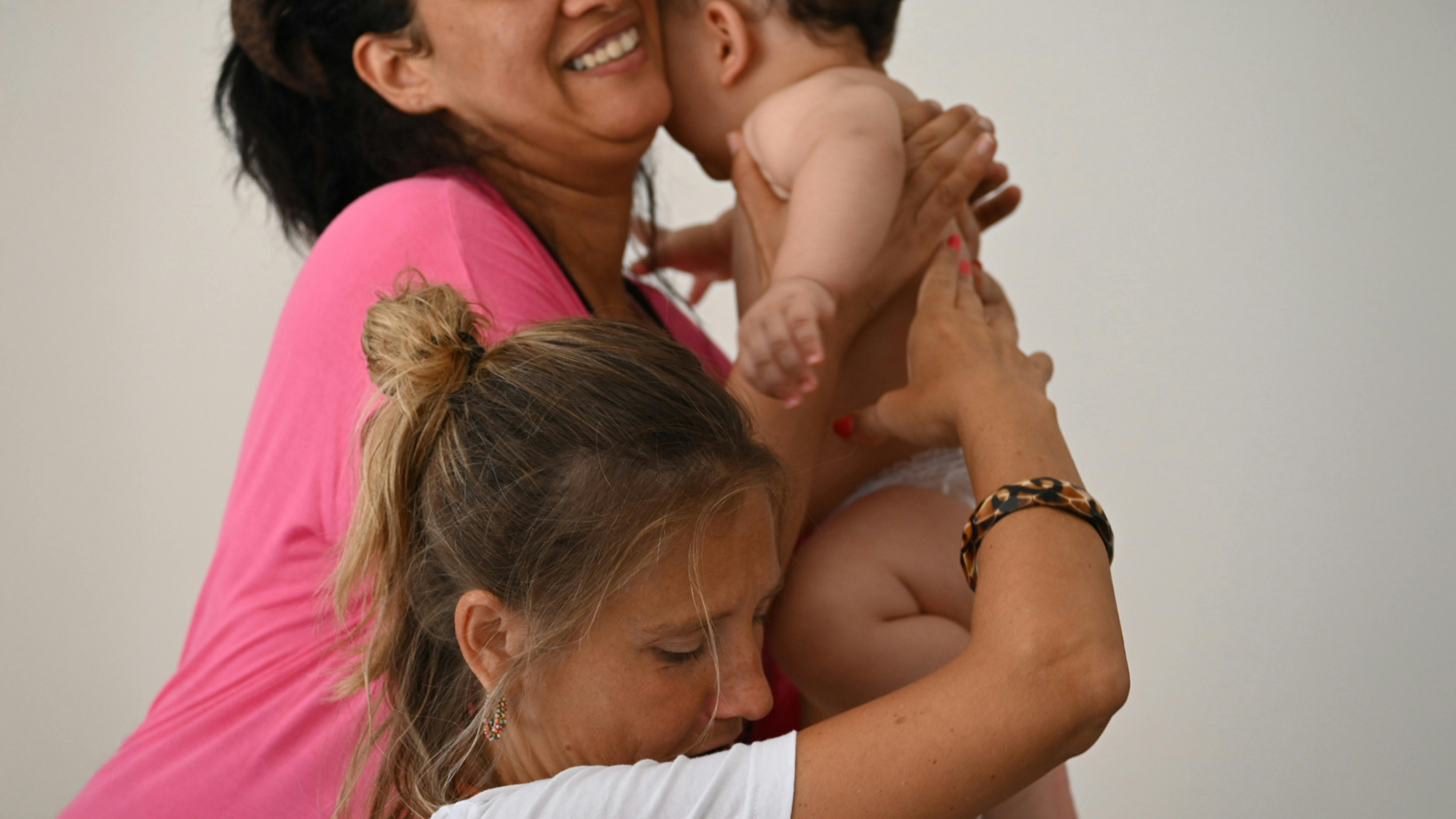 Un’operatrice Terre des Hommes insieme a una famiglia durante le attività in un centro d’accoglienza. © UNICEF/Saturnino/2025