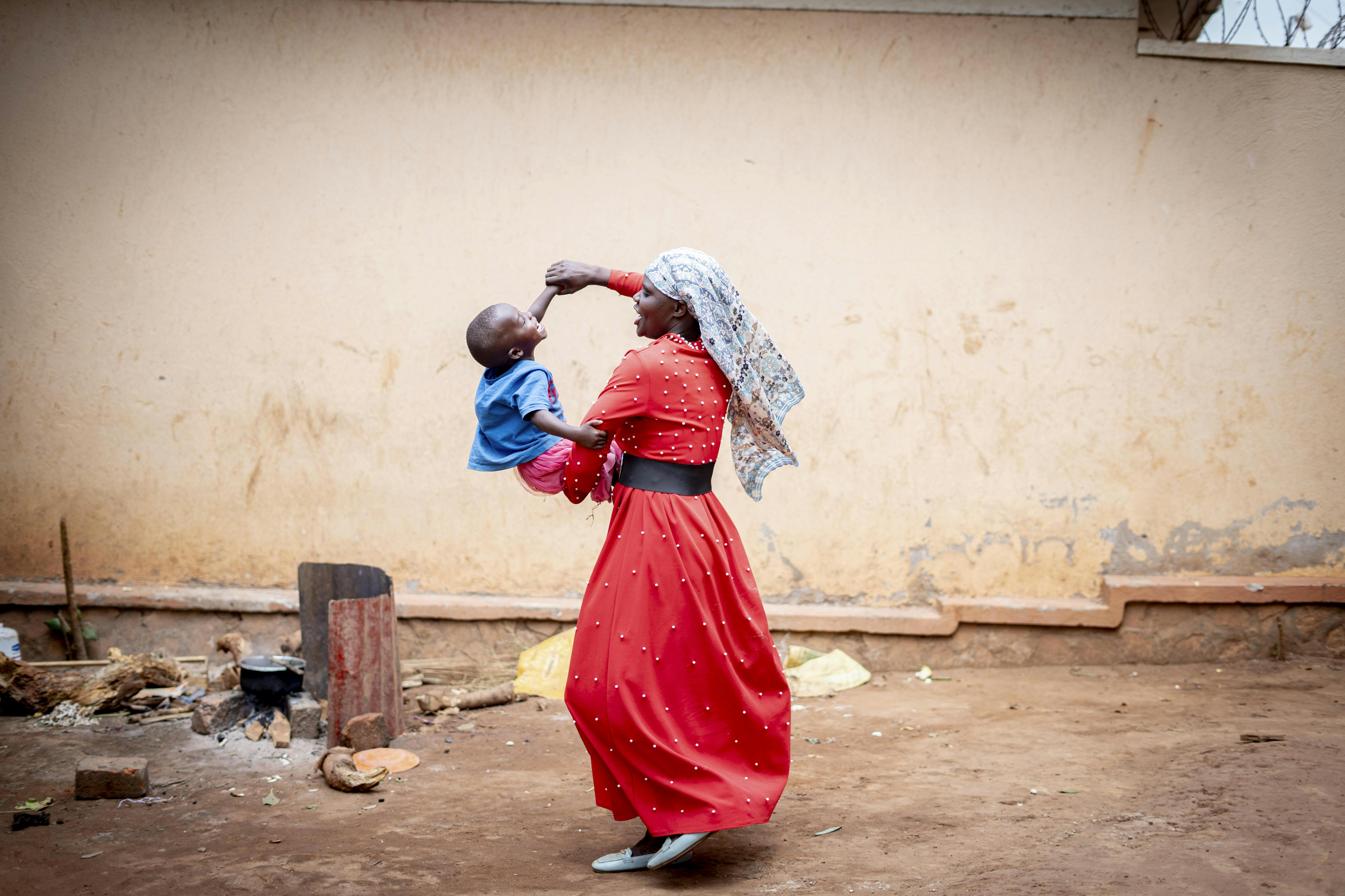 Uganda: Shifra Nabatanzi gioca con il suo bambino di due anni, sopravvissuto al mpox, davanti casa nel villaggio di Kavumba