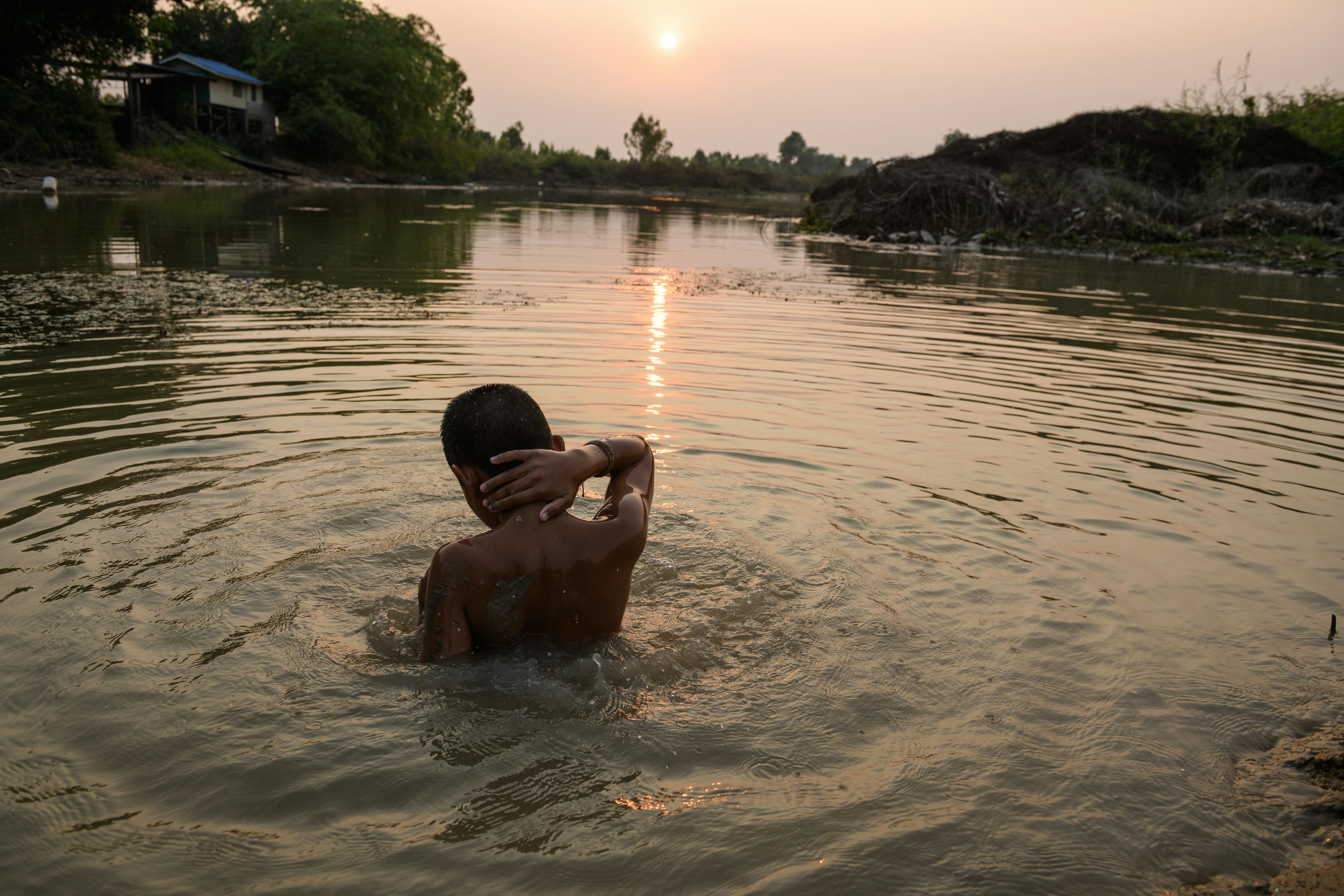Tailandia: Meenakhun Sukma vive lungo le rive del fiume Mun nella provincia di Buriram. Durante il giorno resta a casa per aiutare i nonni con le faccende domestiche. Nel pomeriggio, si rinfresca giocando nel fango e nuotando nel fiume—la sua attività preferita. Lo aiuta a sfuggire al caldo che si accumula durante la giornata torrida. La Thailandia si classifica come il nono paese più influenzato dal clima a livello globale secondo il Global Climate Risk Index.