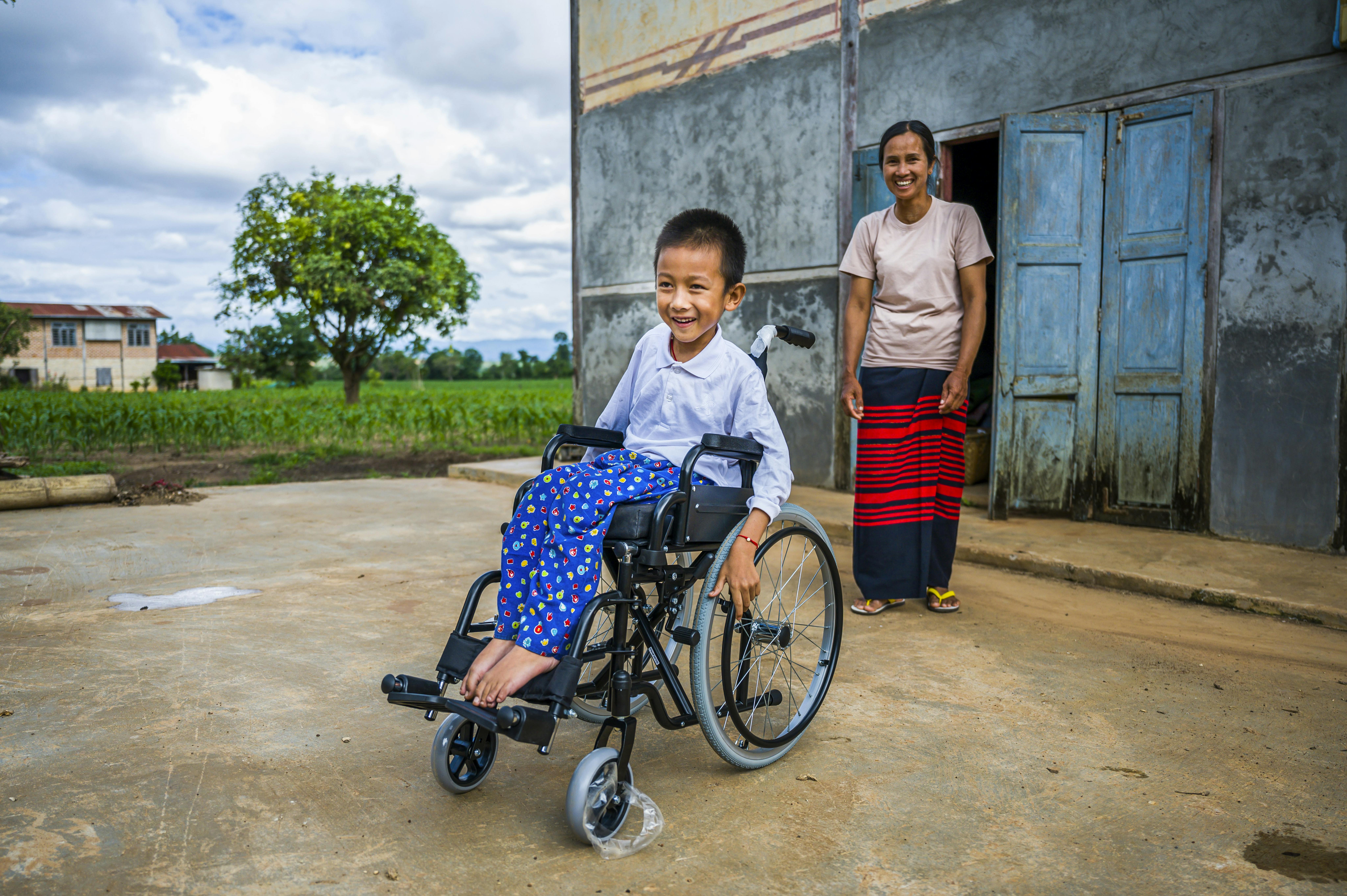 Myanmar: Khit Thit Kha, 8 anni, esplora la sua casa nel villaggio con la nuova sedia a rotelle ricevuta grazie al programma dell'UNICEF per bambini disabili.