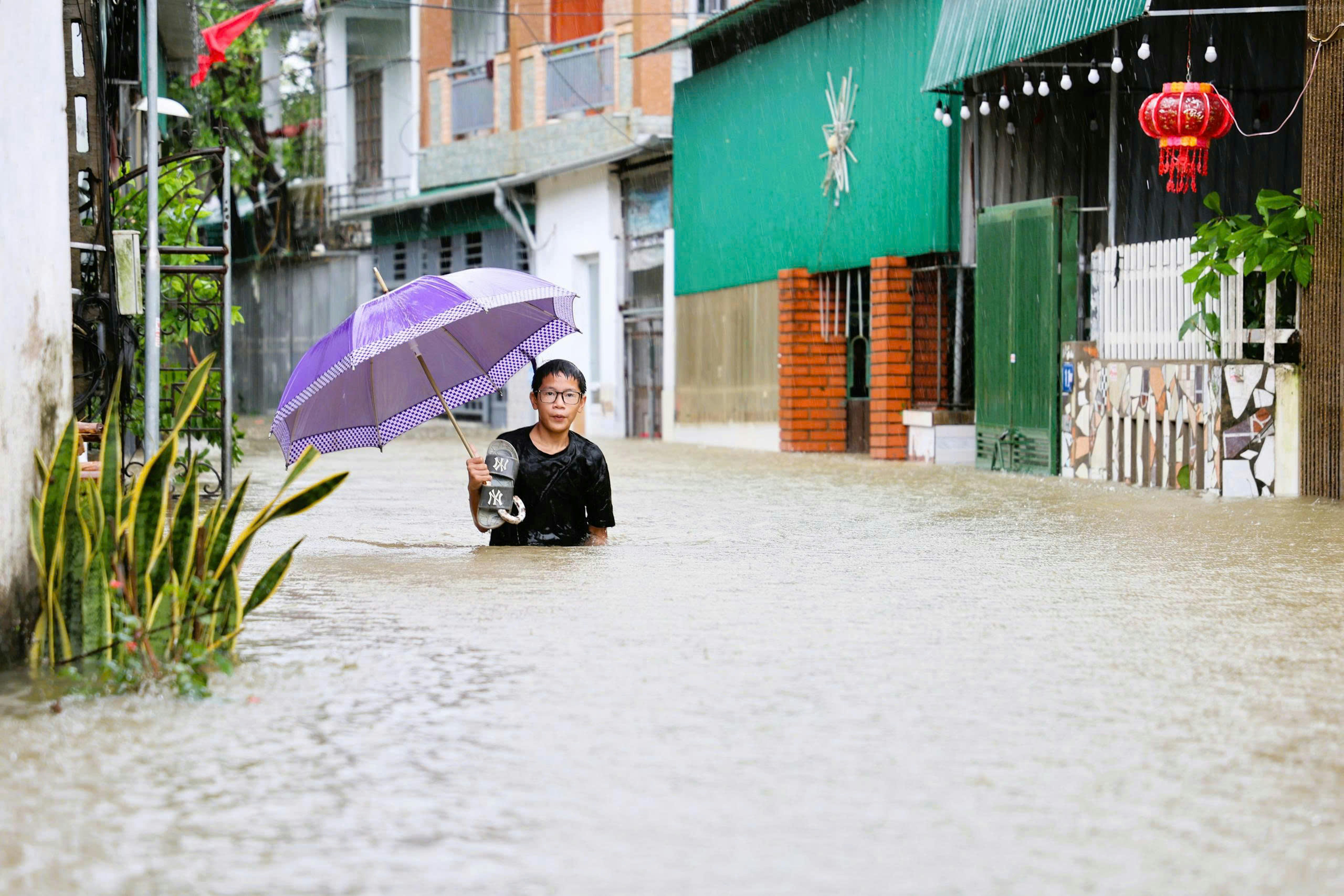 Vietnam: Hoang Trung Thanh, 15 anni, si trova in una zona allagata nel quartiere di Truong Vinh. Dopo la tempesta tropicale Bualoi del settembre 2025, che ha portato venti potenti e sostenuti, forti piogge e mareggiate