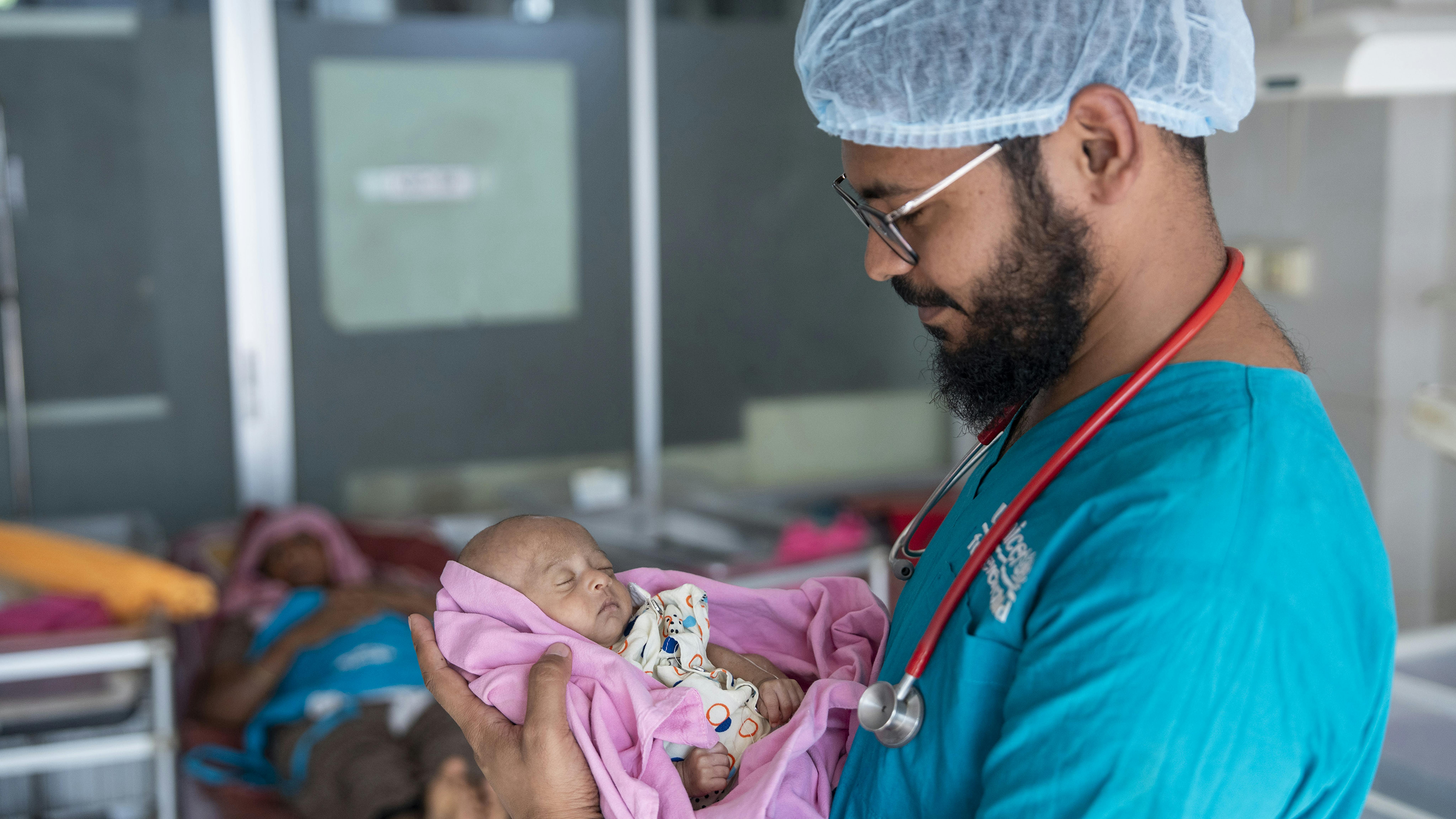Il dottor Imtiaz Hossain Sakib, membro dello staff dell'ospedale supportato dall'UNICEF, tiene in braccio Sarid di un mese durante un controllo post-esame presso l'ospedale Sadar del distretto di Cox's Bazar
