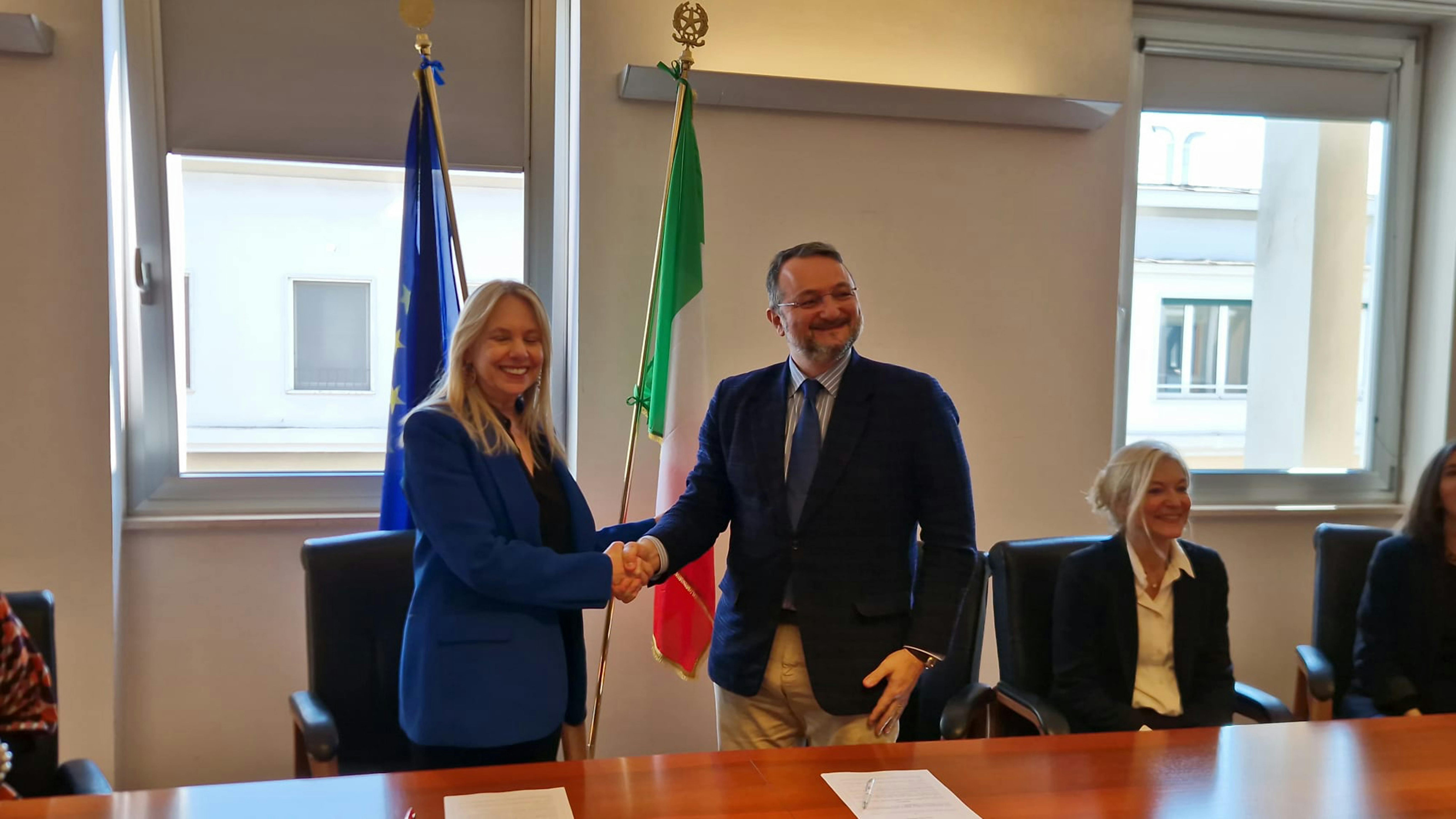Paola Nicastro (SLI) e Nicola Dell’Arciprete (UNICEF ECARO) si stringono la mano dopo la firma del protocollo