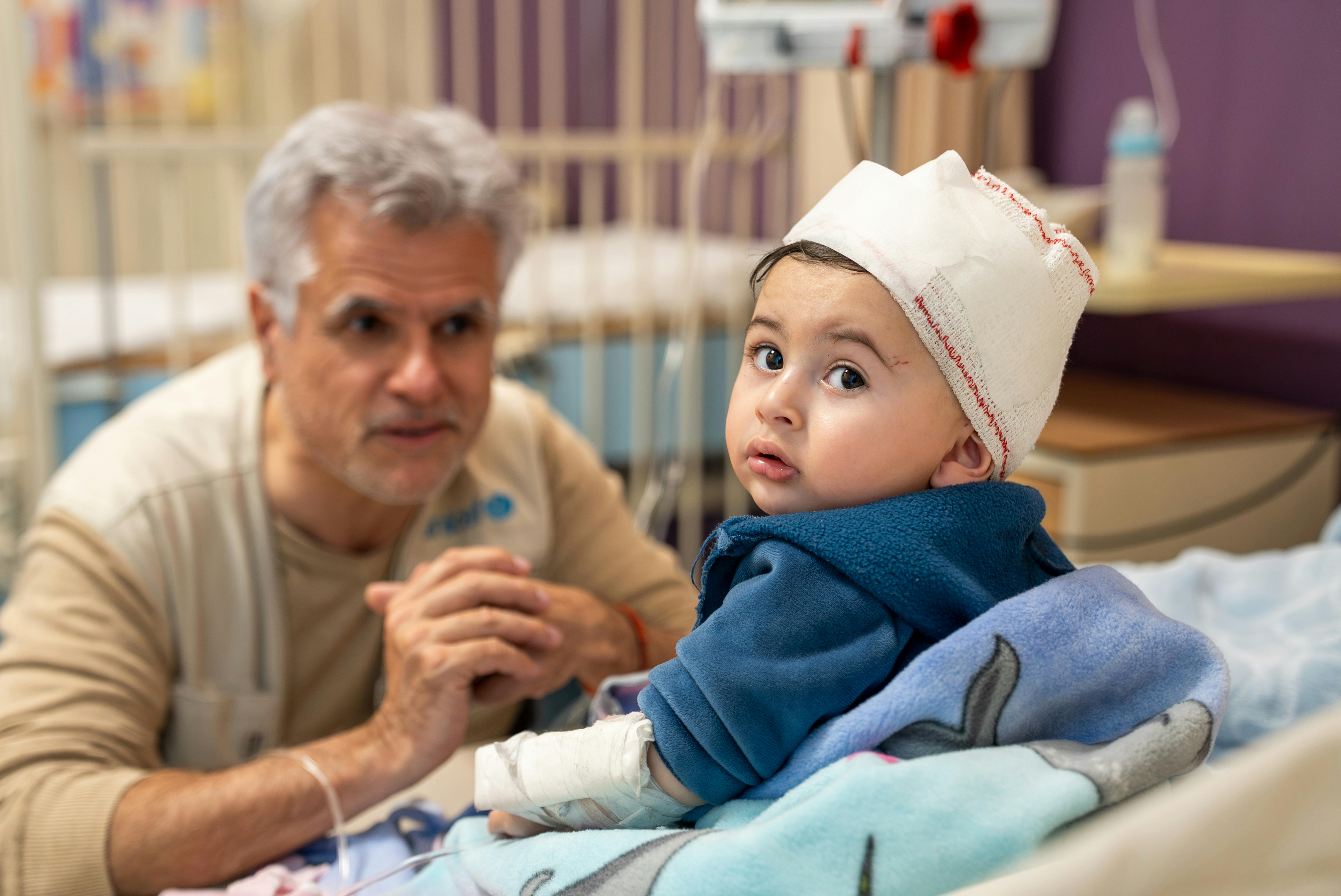 Libano: Ahmad è seduto su un letto avvolto in una coperta all’Ospedale Governativo Rafic Hariri di Beirut, dove è in cura, e interagisce con Christophe Boulierac, Capo della Comunicazione e dell’Advocacy di UNICEF Libano.