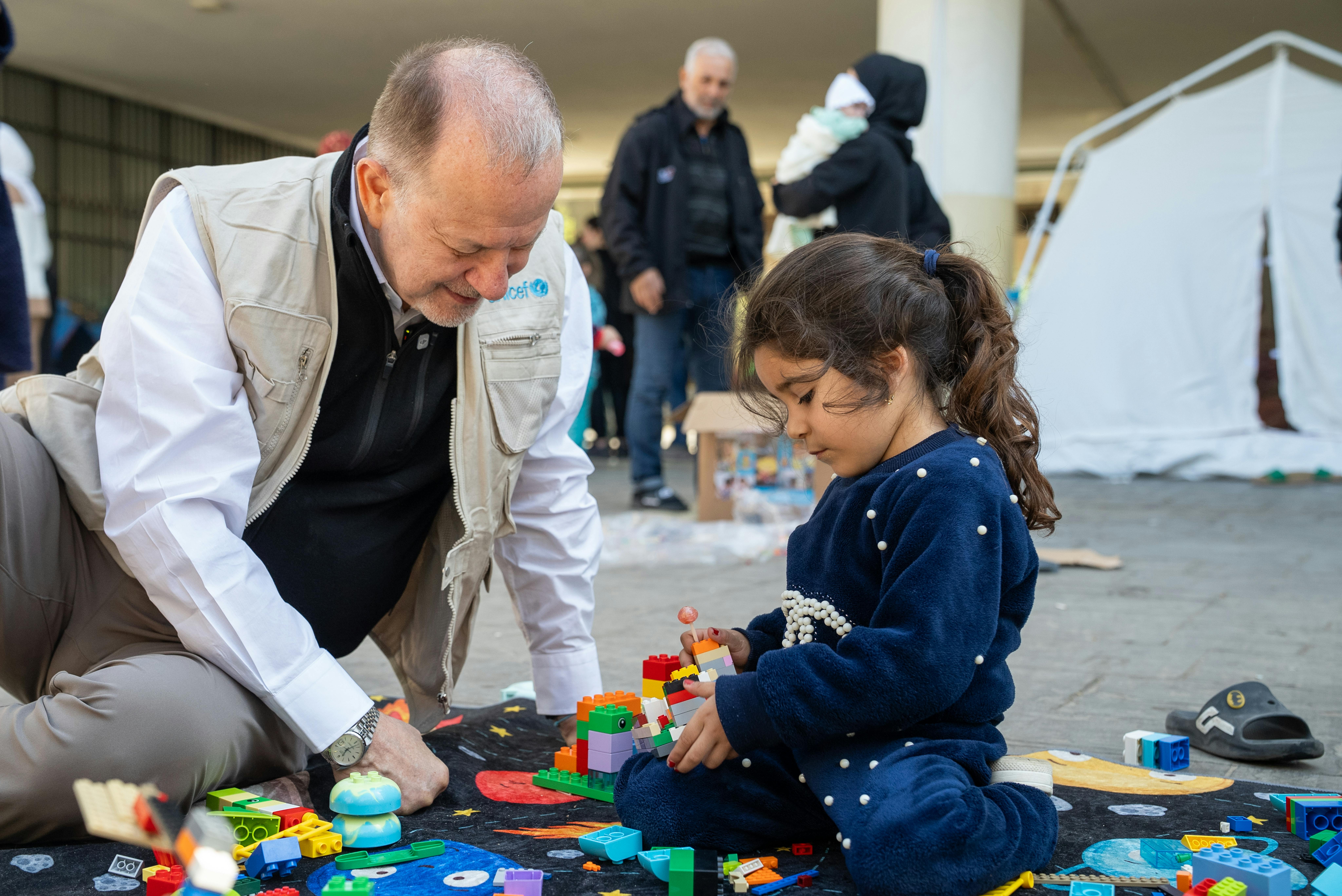 Il 17 marzo 2026, Ted Chaiban siede e gioca con Mira, 5 anni, mentre incontra bambini e famiglie sfollate ospitate nella scuola Omar Faroukh a Beirut.