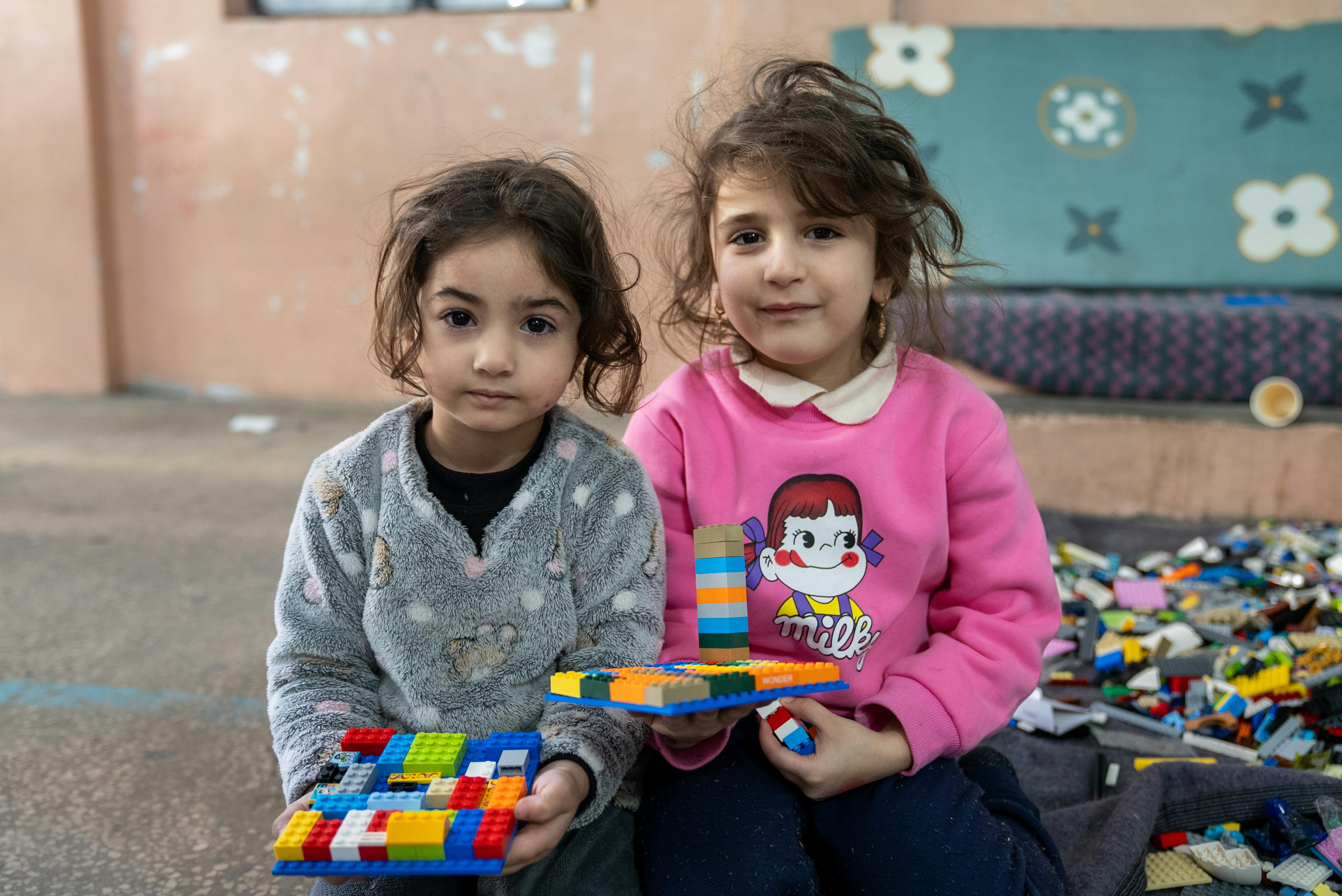 Narjes, 3 anni, e Malika, 4 anni, posano insieme mentre giocano con i LEGO nella scuola Omar Faroukh a Beirut, dove centinaia di sfollati interni sono ospitati dopo la fuga dalle violenze.