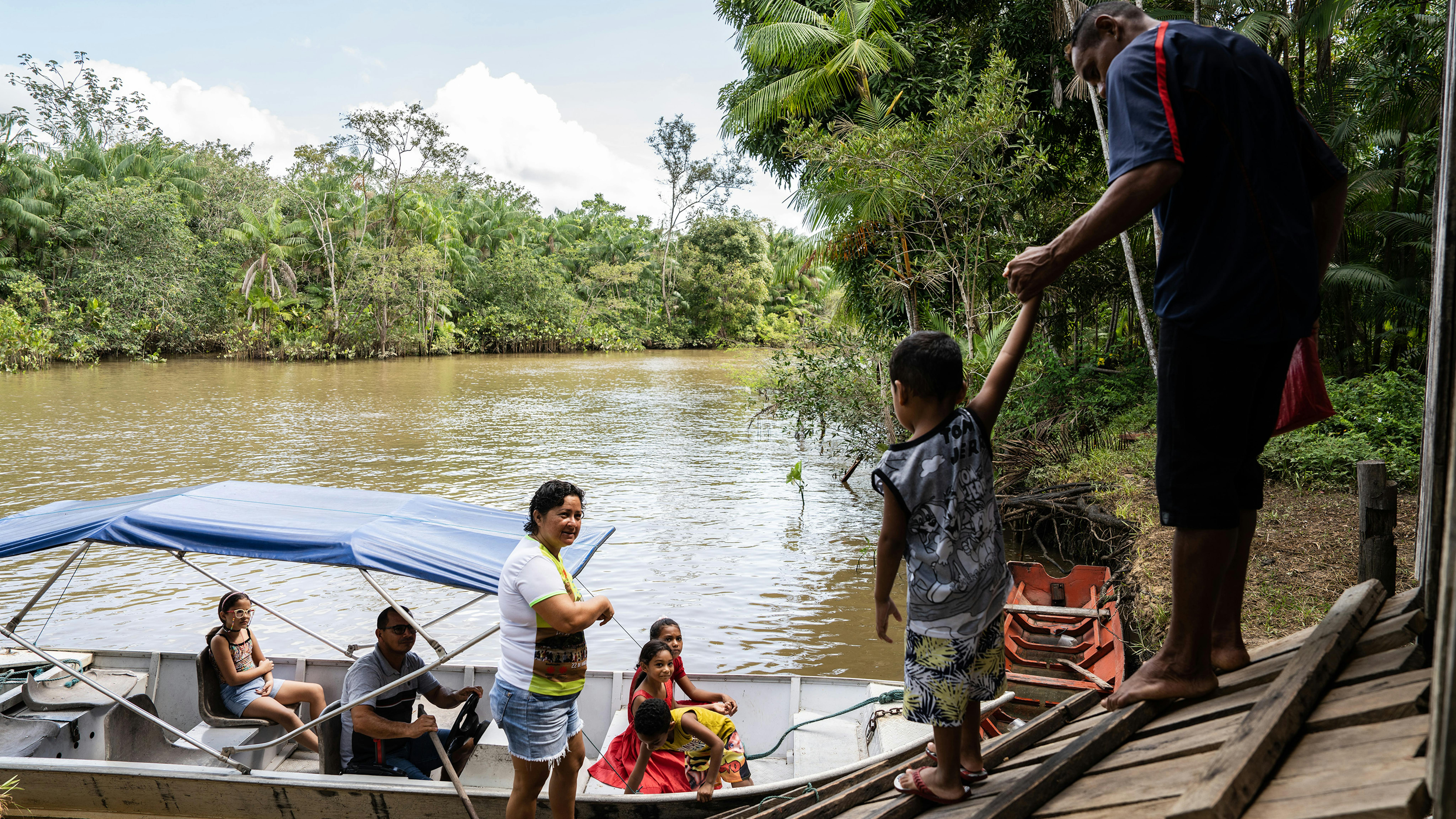 Dene Maria Rodrigues André, agente sanitario per la comunità, accompagna una famiglia al centro sanitario locale per vaccinare i bambini. Questo Comune nel nord del Brasile è formato da 72 isole, per cui gli operatori sanitari devono spostarsi in barca per raggiungere le comunità.