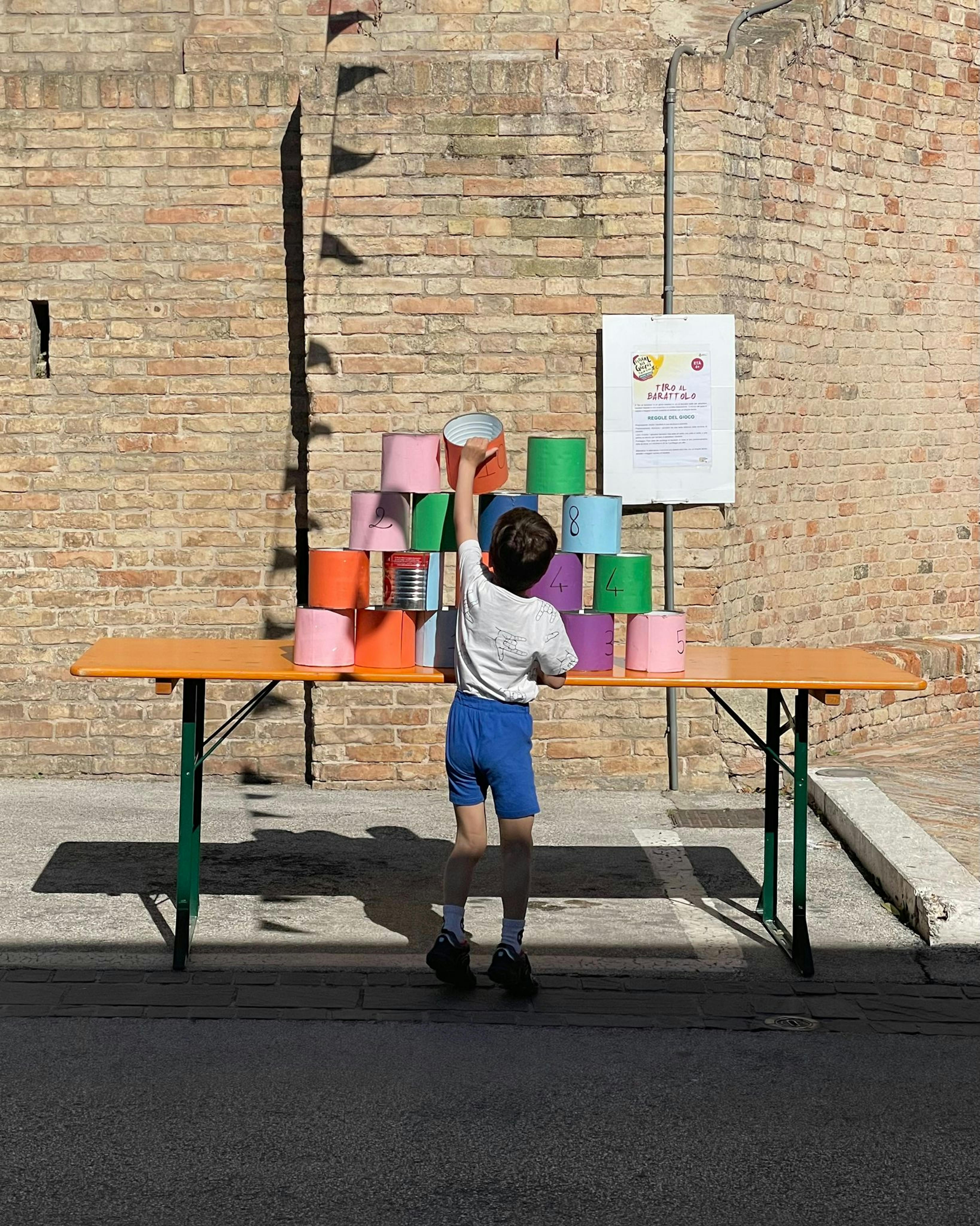 Un bambino sistema le latte del tiro a bersaglio nella giornata dedicata al Diritto al Gioco 2026. Siamo a Monte Urano, Fermo