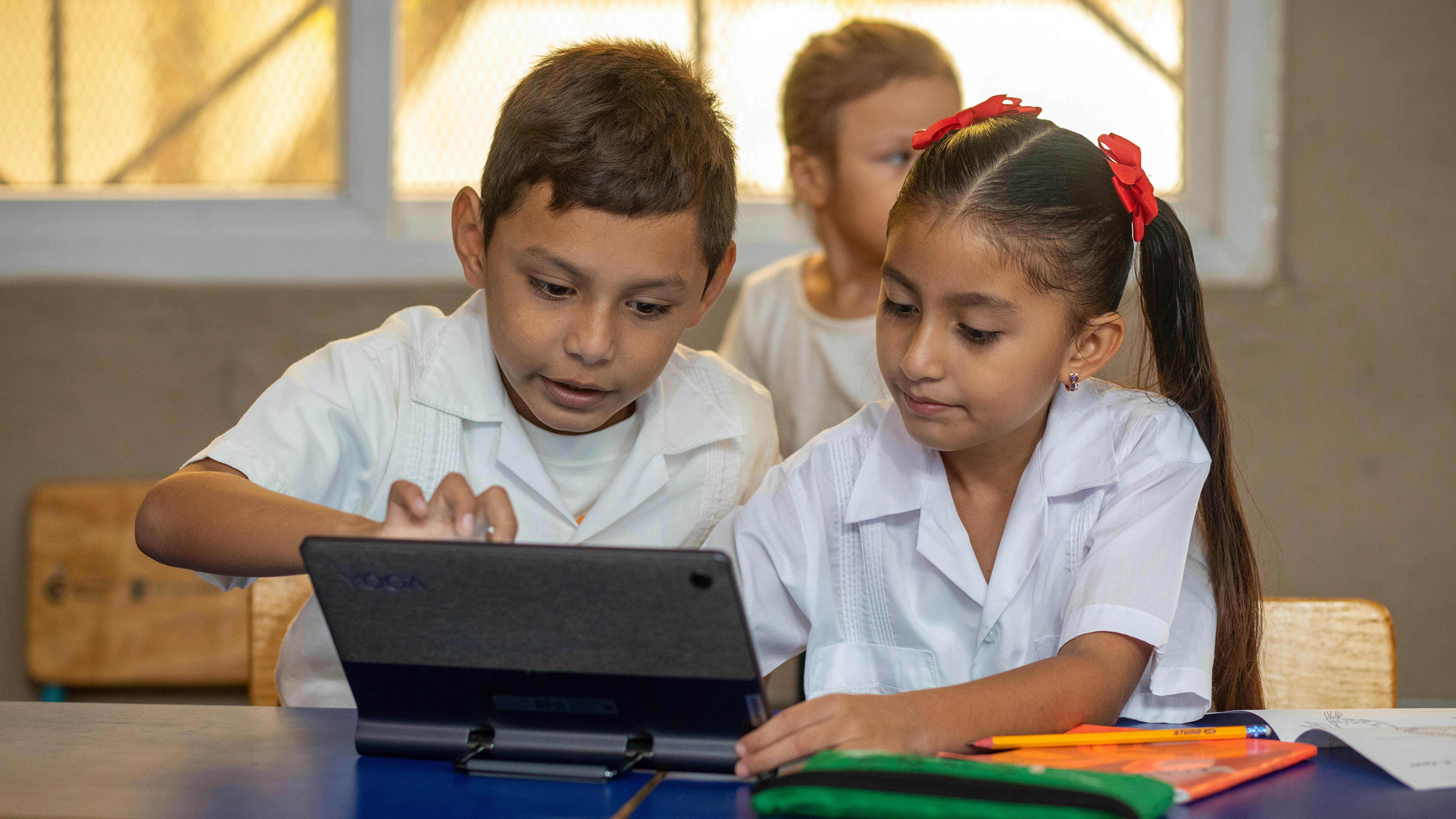 Studenti in una scuola in Honduras utilizzano tablet connessi grazie al progetto Giga, promosso da UNICEF, per migliorare l’accesso all’apprendimento digitale.