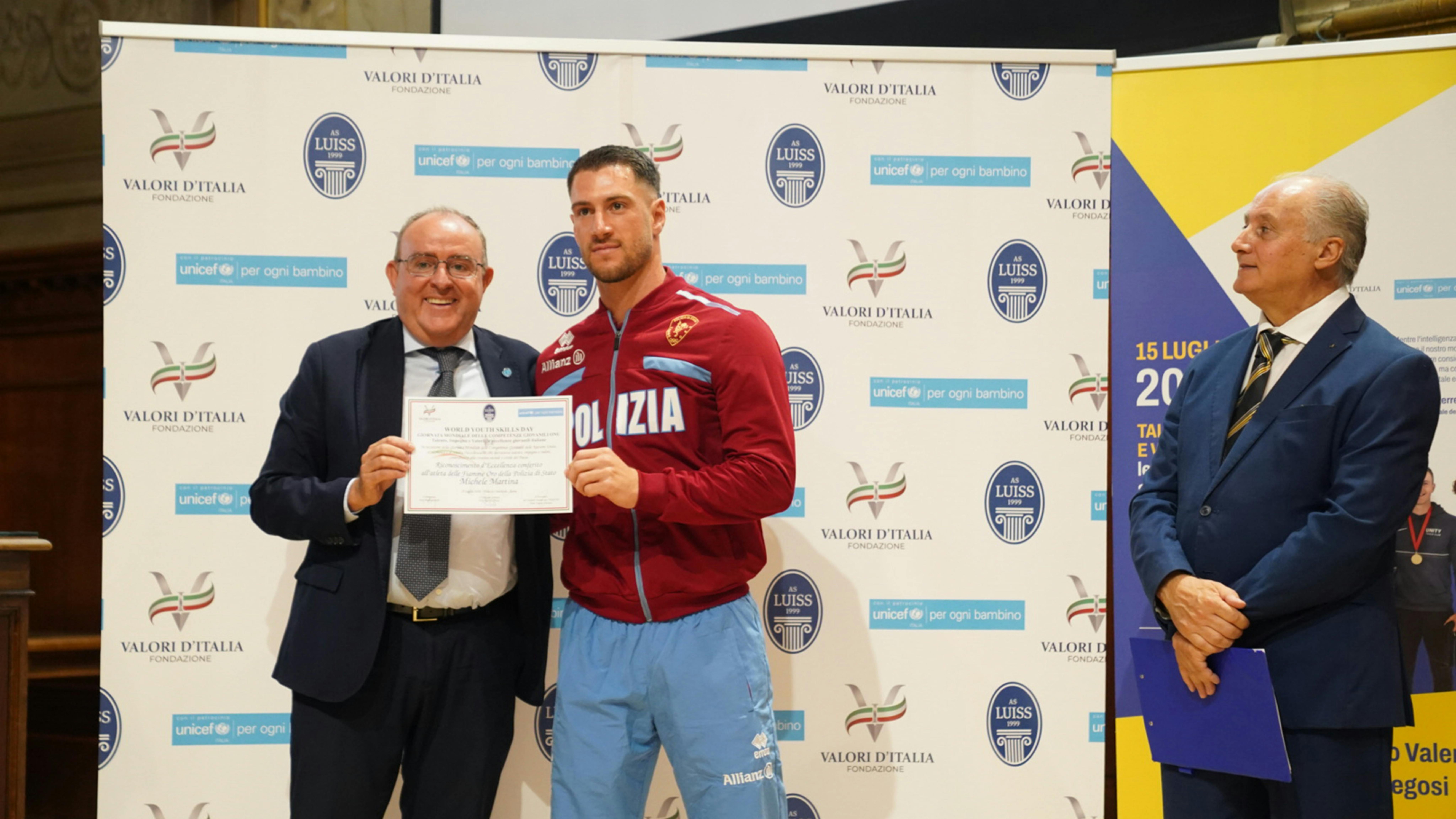 Da sinistra Il Presidente dell'UNICEF Italia Nicola Graziano premia un atleta delle Fiamme Oro